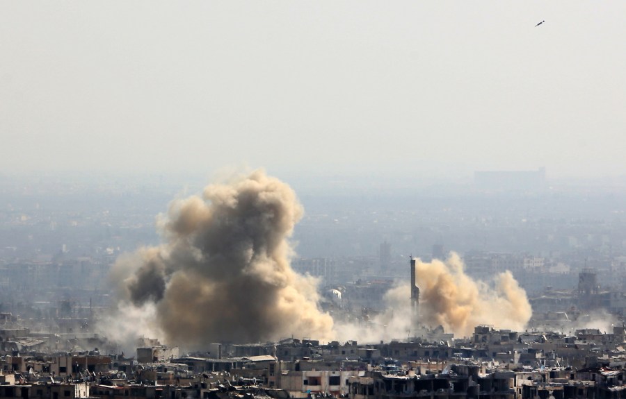 A picture taken from a government-controlled area on the outskirts of Harasta on the northeastern suburbs of Damascus on February 21, 2018, shows smoke rising from areas targeted by Syrian army shelling in the towns of Arbin and Harasta. (STRINGER/AFP/Getty Images)