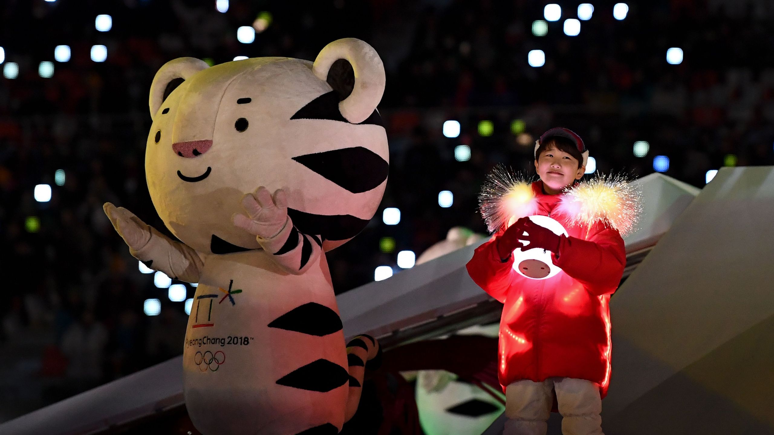 An entertainer holds a lit globe next to a performer dressed as the official mascot Soohorang during the closing ceremony of the Pyeongchang 2018 Winter Olympic Games at the Pyeongchang Stadium on Feb. 25, 2018. (Credit: JONATHAN NACKSTRAND/AFP/Getty Images)