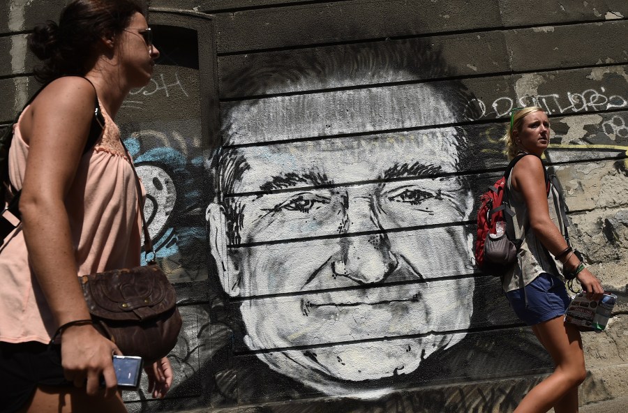 People walk past a mural depicting actor Robin Williams in downtown Belgrade on Aug. 13, 2014. (Credit: ANDREJ ISAKOVIC/AFP/Getty Images)