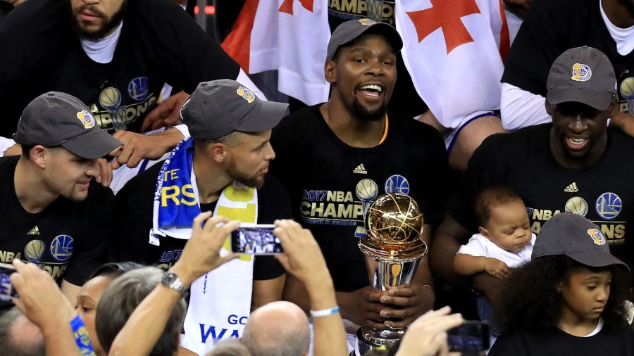 Klay Thompson, JaVale McGee, Stephen Curry, Kevin Durant #35 with the Bill Russell NBA Finals Most Valuable Player Award, and Draymond Green of the Golden State Warriors celebrate after defeating the Cleveland Cavaliers 129-120 in Game 5 to win the 2017 NBA Finals at ORACLE Arena on June 12, 2017 in Oakland. (Credit: Ronald Martinez/Getty Images)