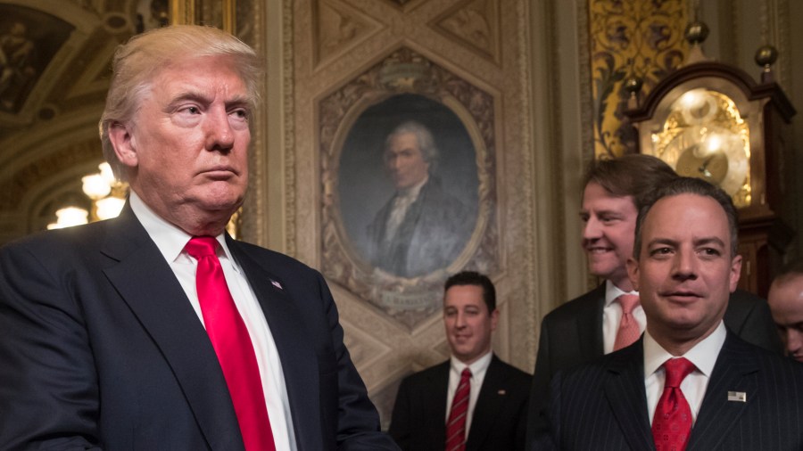 President Donald Trump leaves the President's Room of the Senate at the Capitol after he formally signed his cabinet nominations into law, in Washington, Jan. 20, 2017. At far right is Chief of Staff Reince Priebus, with White House counsel Donald McGahn, second from right. (Credit: J. Scott Applewhite - Pool/Getty Images)