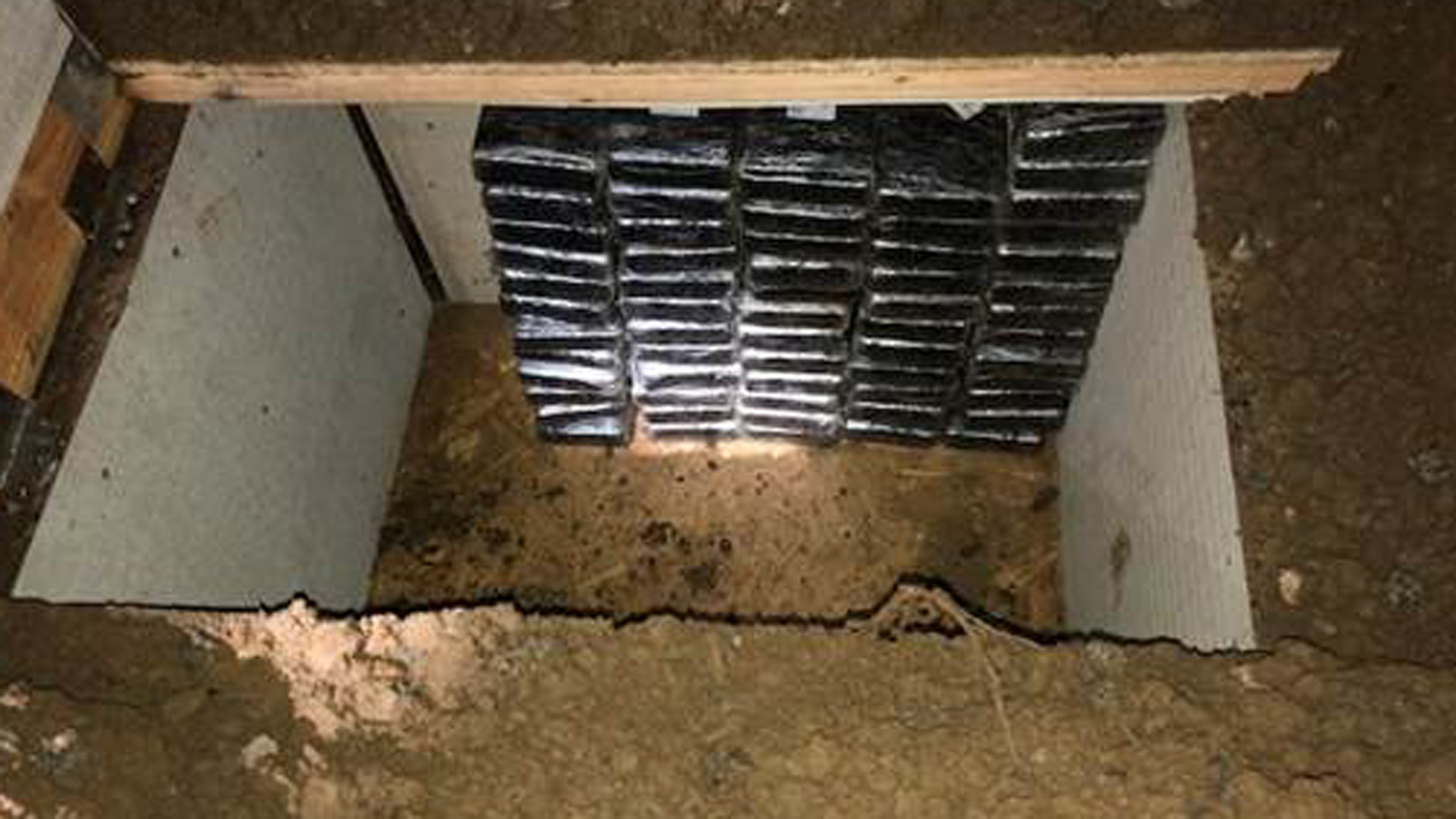 Stacks of cocaine are seen inside an underground bunker that was discovered in the backyard of an Inland Empire home where investigators uncovered about $8.4 million in cocaine. Authorities announced the seizure and arrests of two men in connection with it on March 23, 2018. (Credit: Orange County Sheriff's Department)