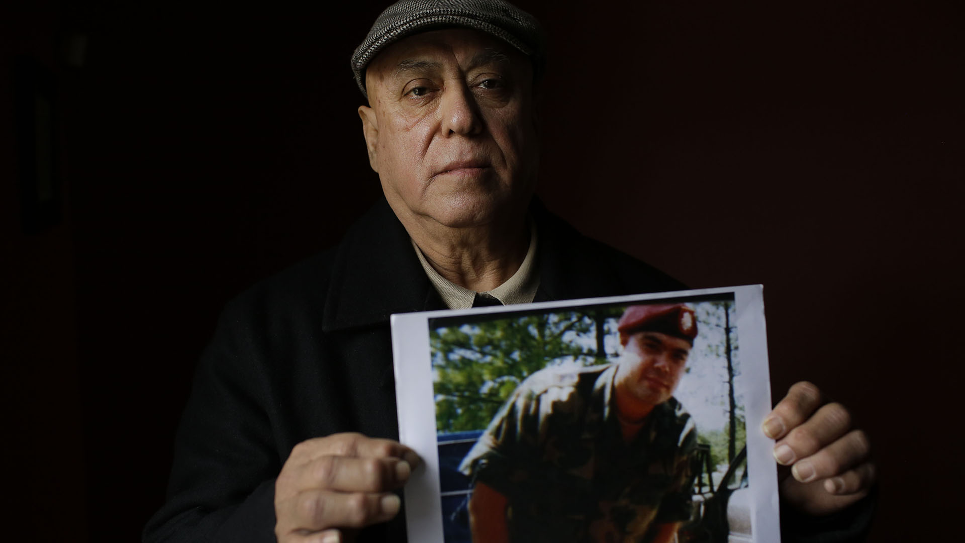 Miguel Perez poses as he holds a photo of his son Miguel Perez Jr., on April 4, 2017 in Chicago, Illinois. (Credit: JOSHUA LOTT/AFP/Getty Images)