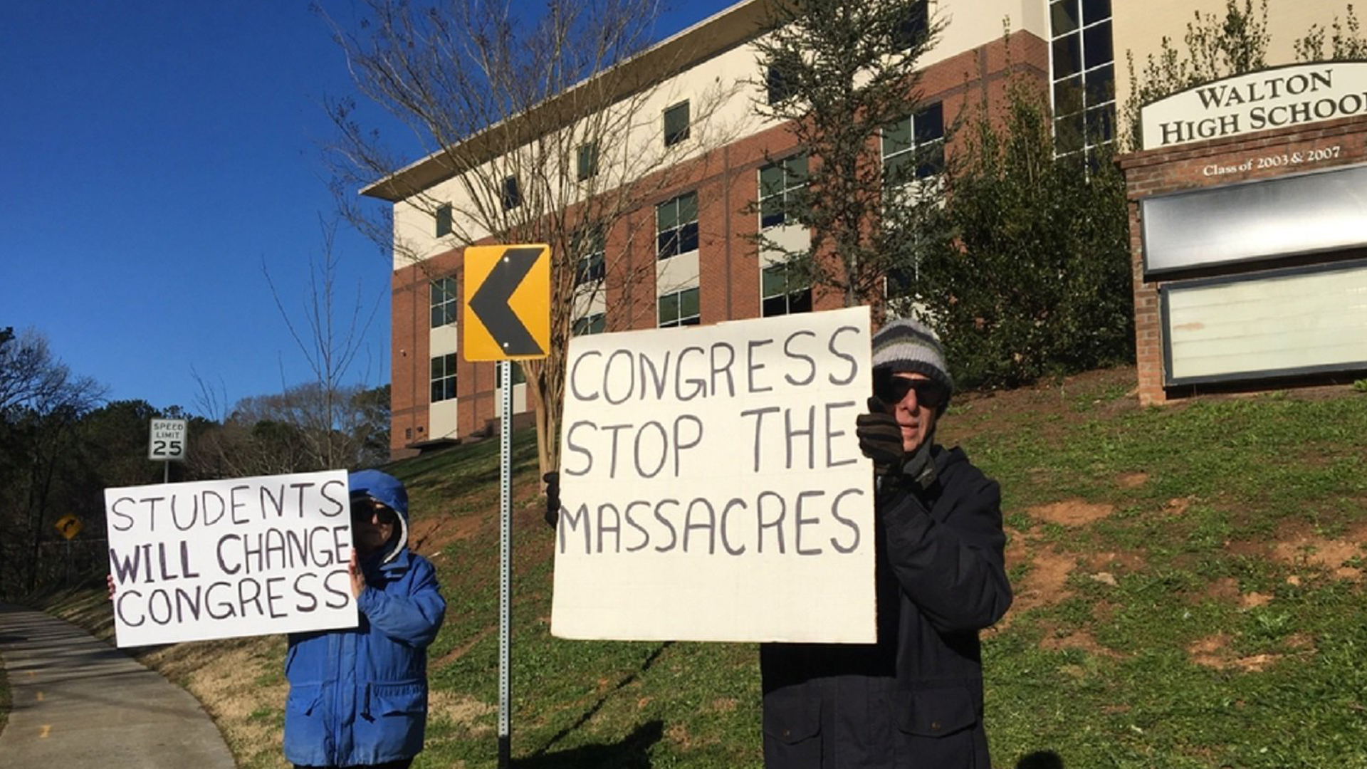 Two parents of students who attend Walton High School in suburban Atlanta protest outside the school as part of nationwide protests against gun violence and in support of school safety on March 14, 2018. (Credit: CNN)