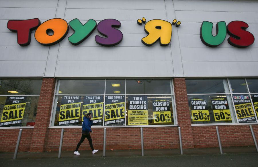 A customer walks outside a Toys "R" Us store with "closing down sale" signs in the windows in south London on Feb. 9, 2018. (Credit: DANIEL LEAL-OLIVAS/AFP/Getty Images)