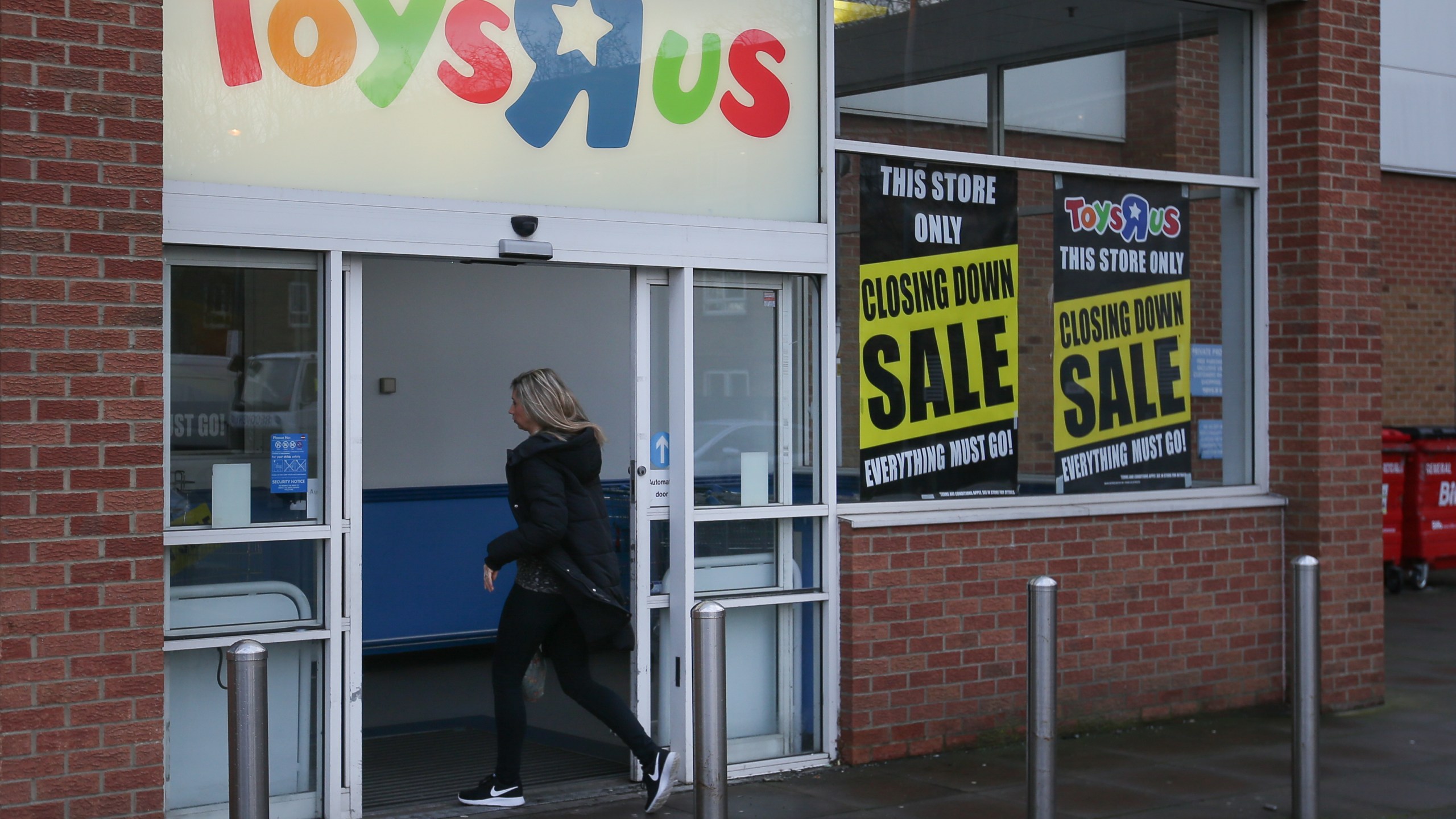 A customer walks inside a Toys 'R' Us store with 'closing down sale' signs in the windows in south London on February 9, 2018. (Credit: DANIEL LEAL-OLIVAS/AFP/Getty Images)