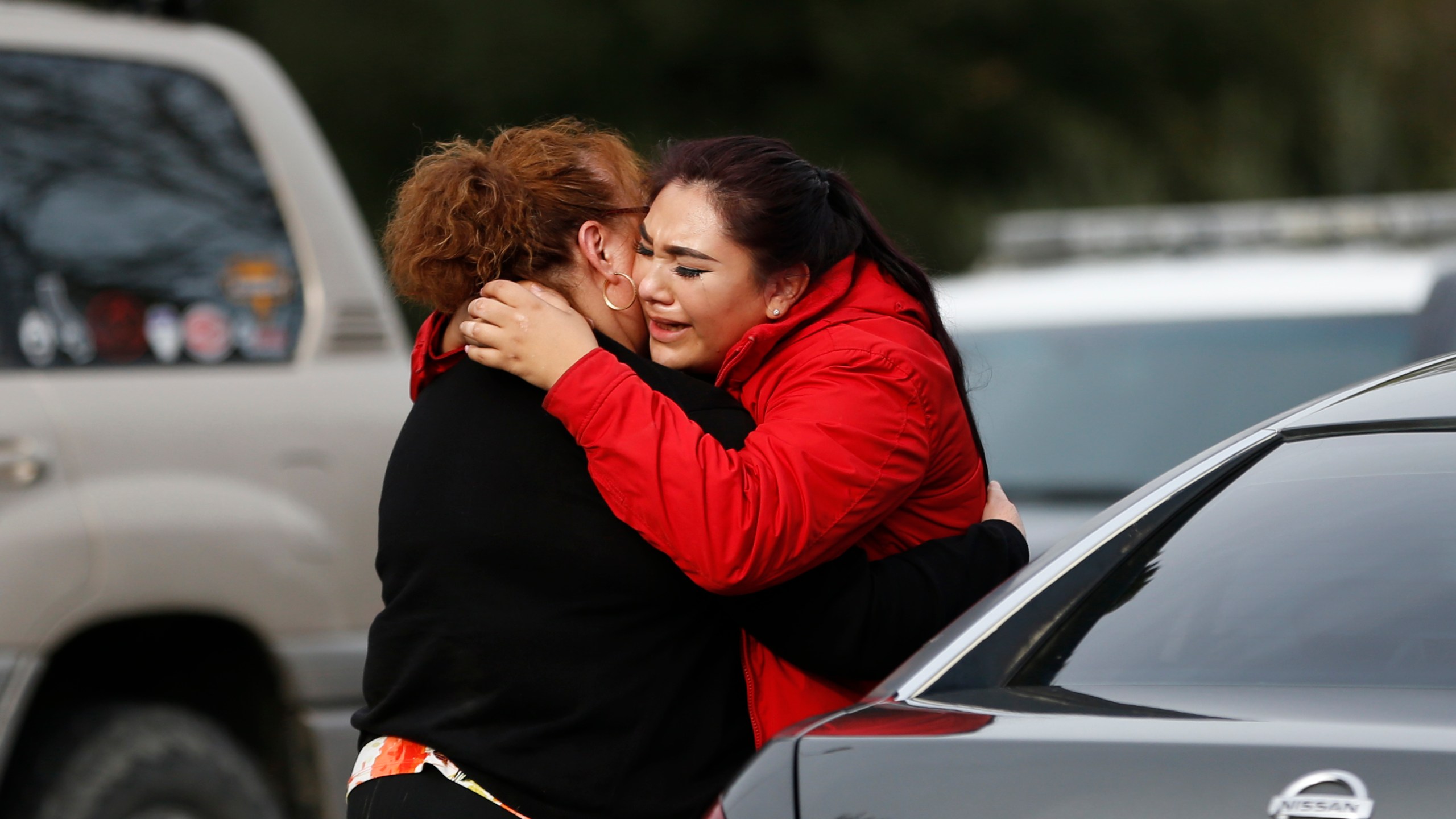 Vanessa Flores, right, embraces another woman after she leaves the locked down Veterans Home of California during an active shooter turned hostage situation on March 9, 2018, in Yountville, California. (Credit: Stephen Lam / Getty Images)