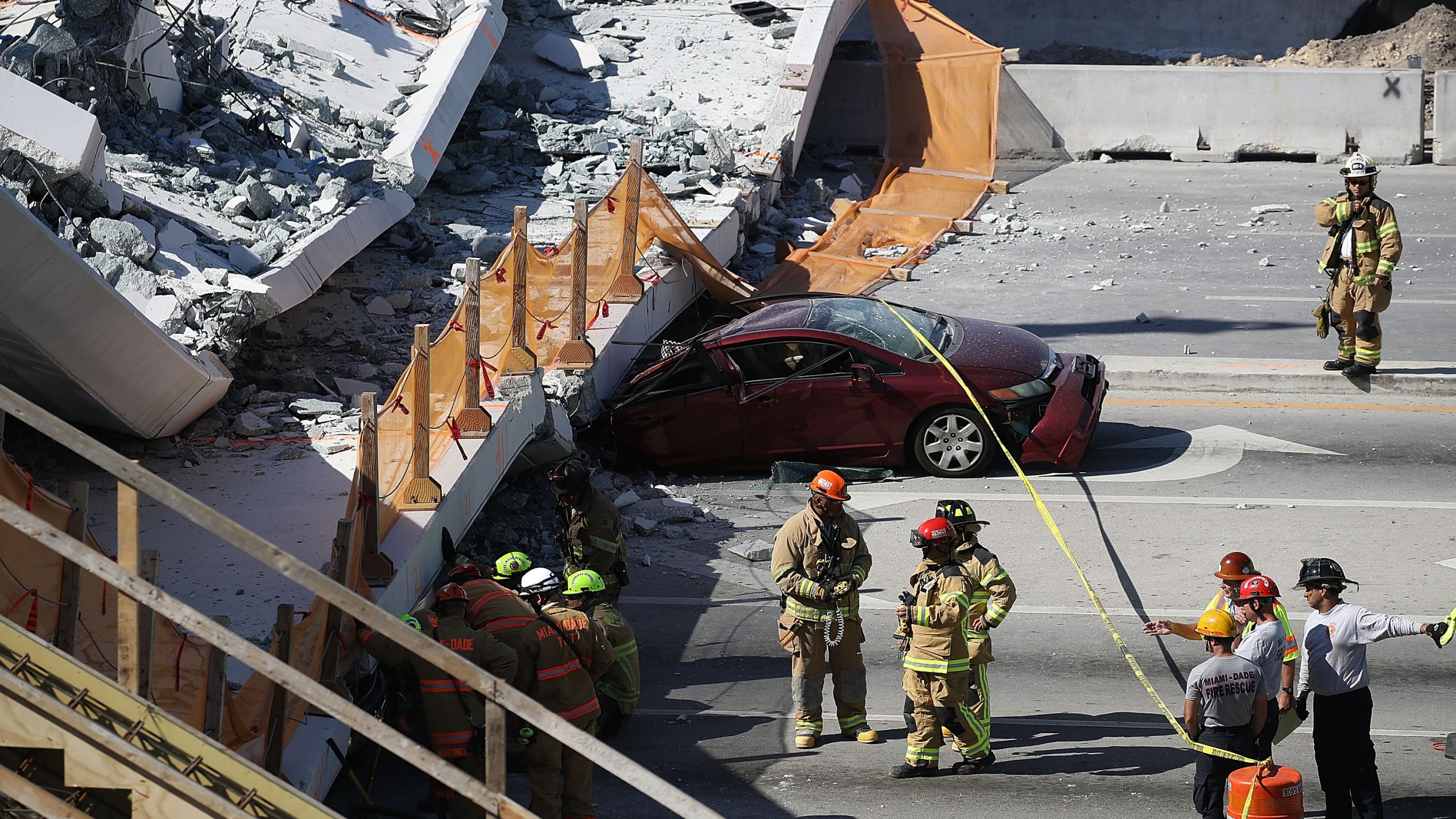 Miami-Dade Fire Rescue Department personnel and other rescue units work at the scene where a pedestrian bridge collapsed a few days after it was built over southwest Eighth Street at Florida International University on March 15, 2018, in Miami. (Credit: Joe Raedle/Getty Images)