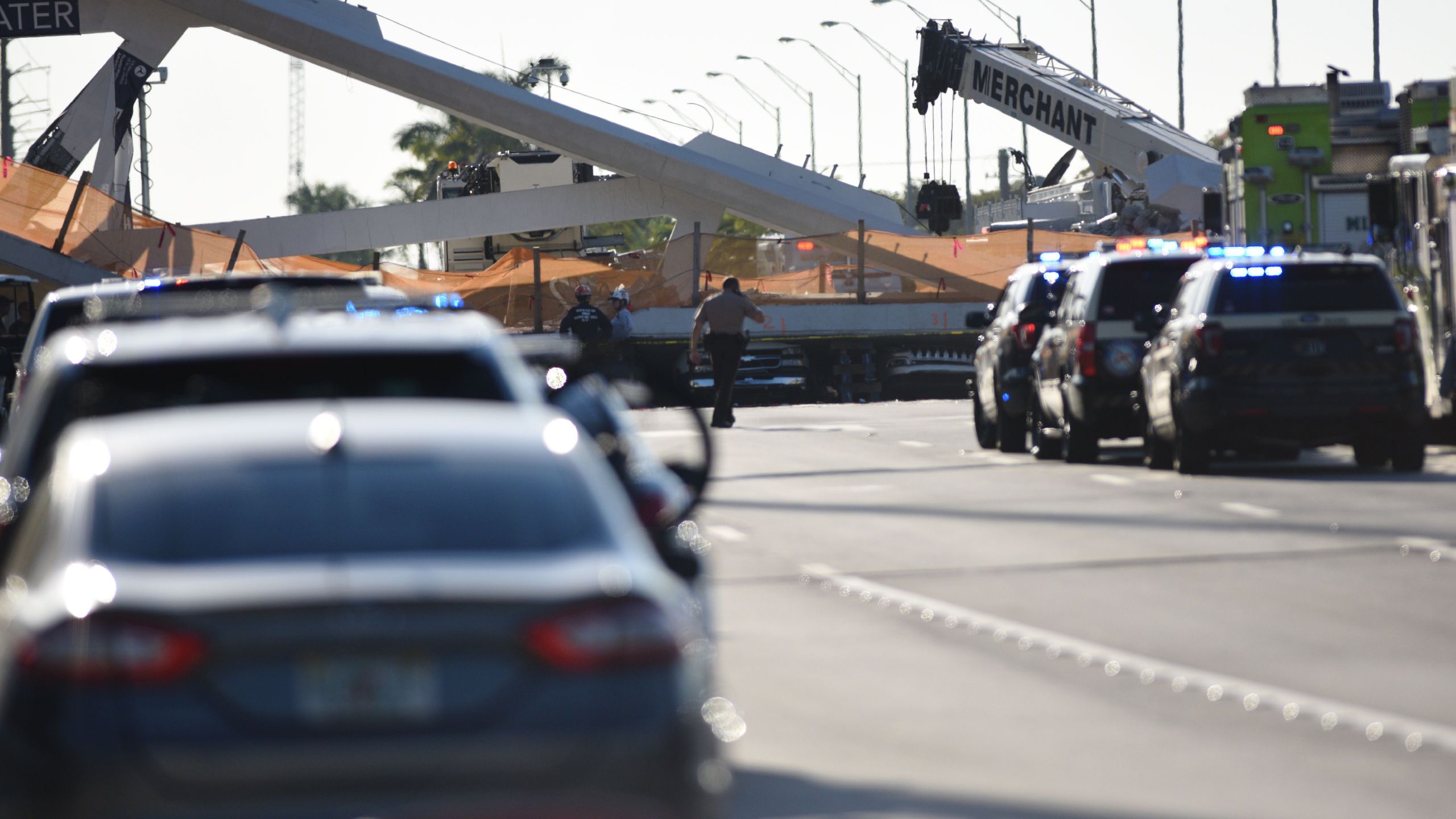 Authorities survey the scene of a pedestrian bridge collapse in Miami, Florida on March 15, 2018, crushing a number of cars below and reportedly leaving several people dead. (Credit: GASTON DE CARDENAS/AFP/Getty Images)