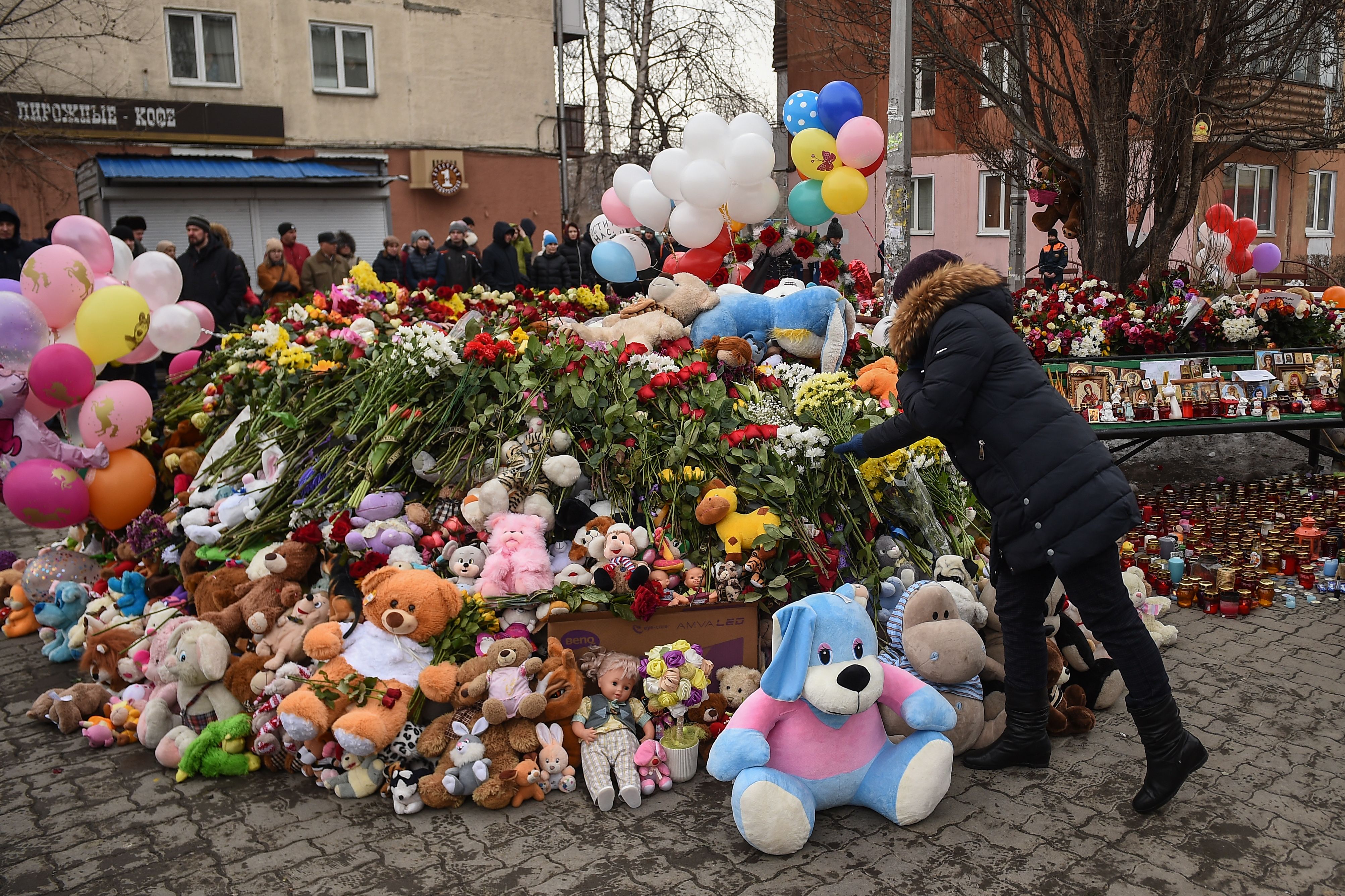 People lay flowers at a makeshift memorial in tribute to the victims of a fire at a shopping center in Kemerovo on March 27, 2018. Russian authorities denounced what they called "flagrant violations" of safety norms that led to the deaths of 64 people, many of them children, in a fire at a busy shopping mall in an industrial city in Siberia. (Credit: DMITRY SEREBRYAKOV/AFP/Getty Images)