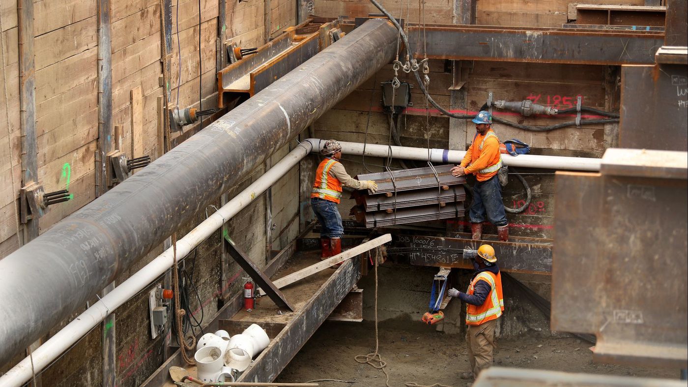 Crews work on an extension of the Metro Purple Line subway at Wilshire Boulevard and La Brea Avenue. A California bill would allow four- to eight-story residential buildings to go up on properties that sit near rail stations and major bus stops. (Credit: Glenn Koenig / Los Angeles Times)