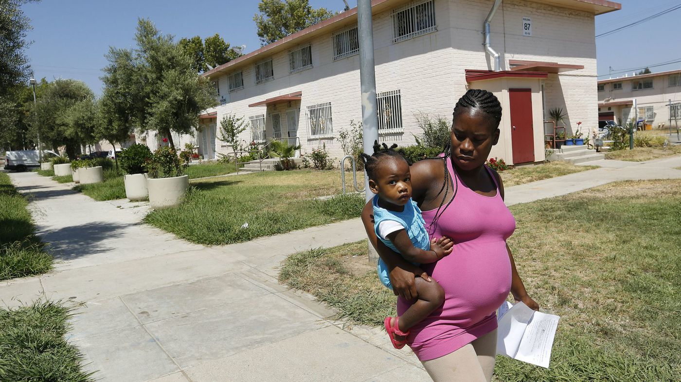 A woman and her child walk home in the Ramona Gardens housing project in Boyle Heights in July 2016. (Credit: Mel Melcon / Los Angeles Times)