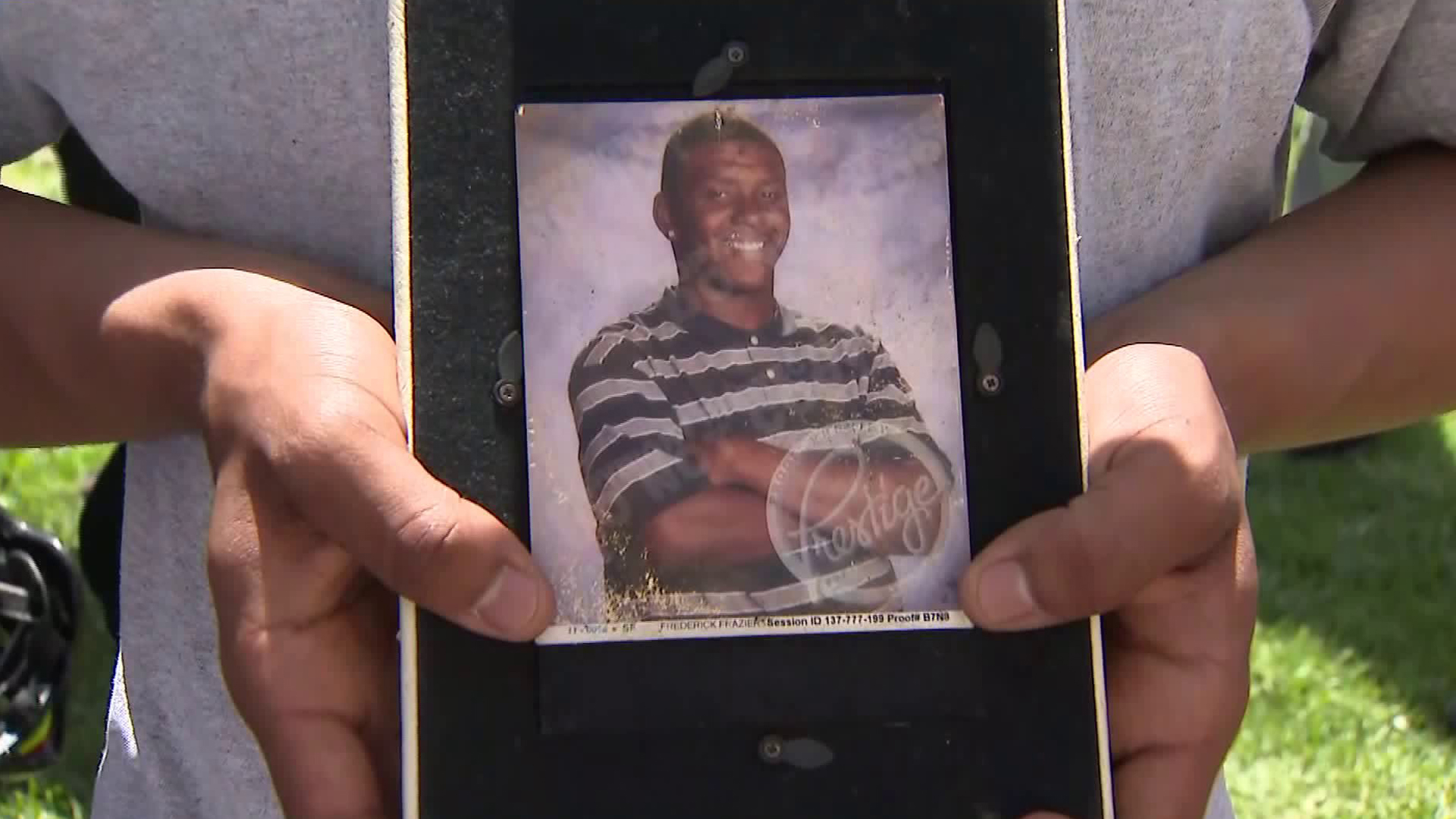 Frederick Frazier is seen in a photo held by a mourner at a vigil for him in South L.A. on April 11, 2018. (Credit: KTLA)