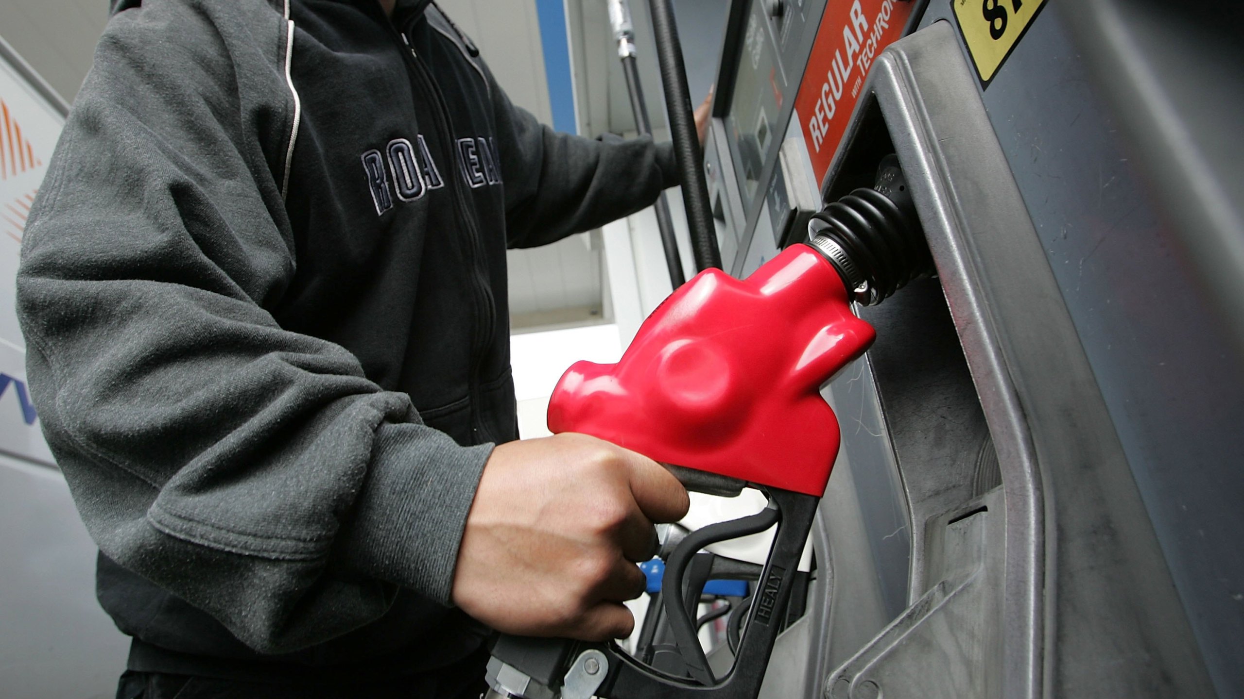 Don Resuerco holds a gas pump before pumping gas into his work van March 27, 2006 in San Francisco. (Credit: Justin Sullivan/Getty Images)