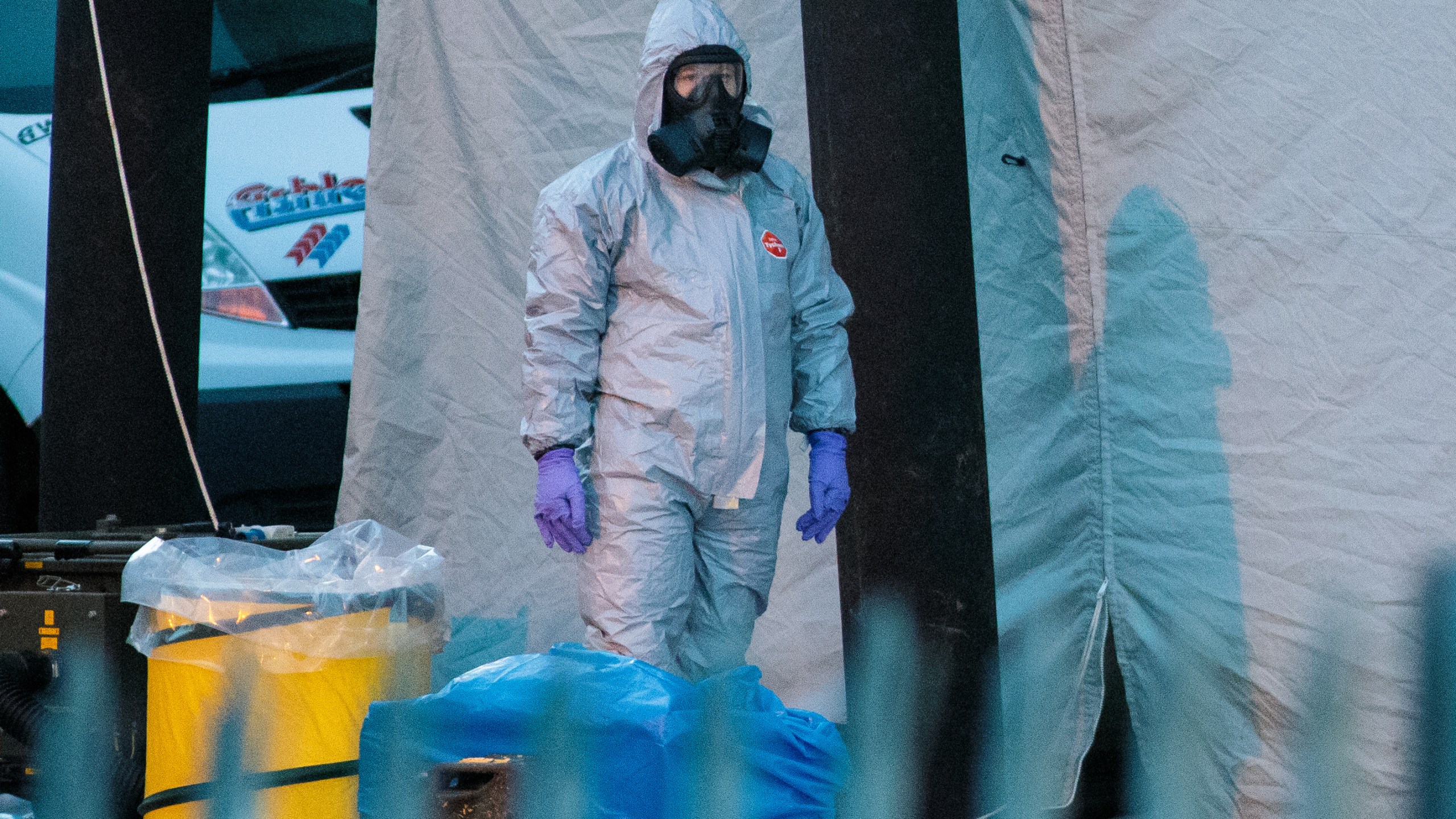 A police officer in a forensics suit and protective mask stands by a forensics tent outside a vehicle recovery centre as investigations continue into the poisoning of Sergei Skripal on March 13, 2018 in Salisbury, England. (Credit: Jack Taylor/Getty Images)