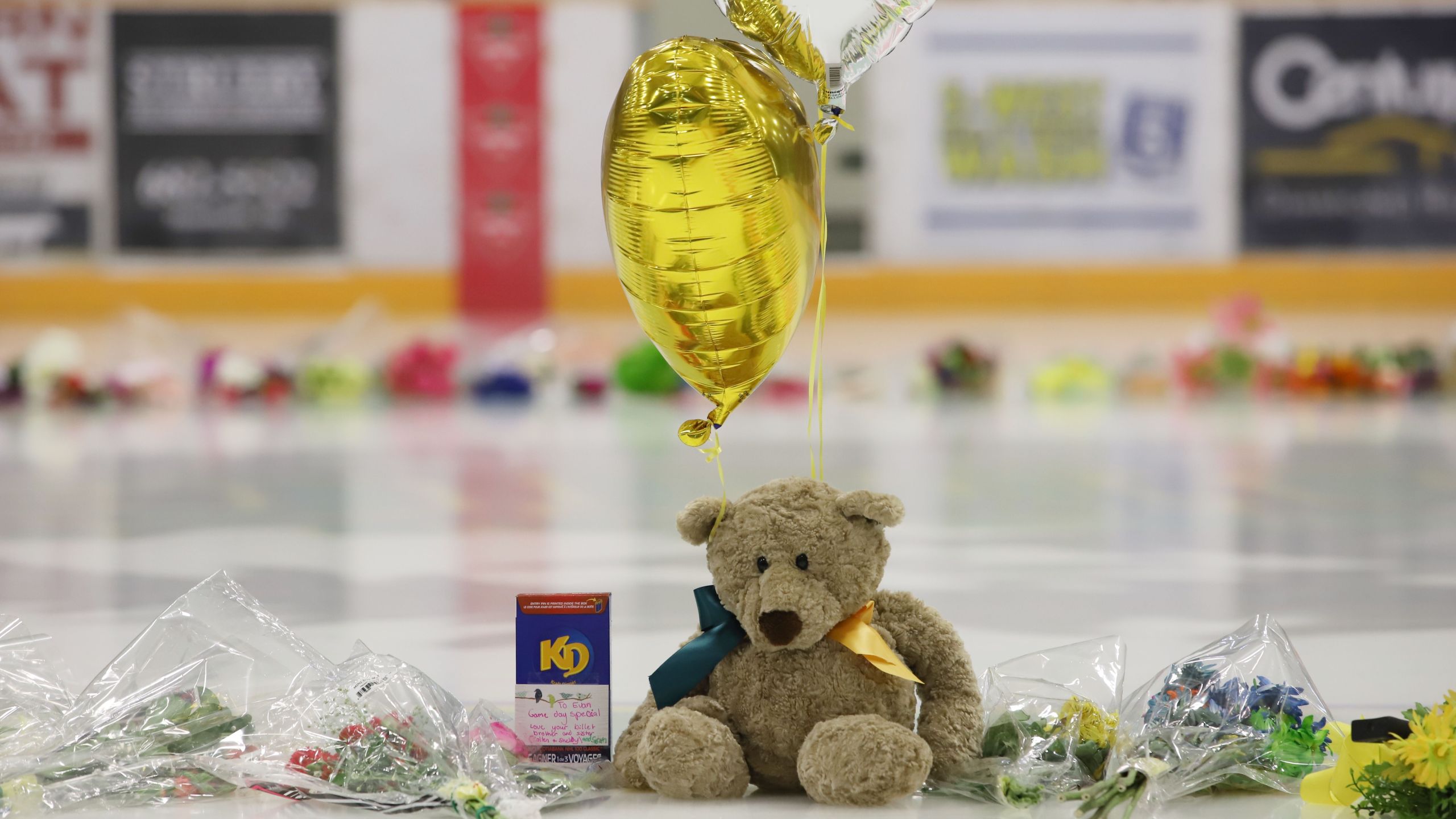 Flowers, cards and sentimental gifts adorn the ice surface at Humboldt Uniplex during preparations for a prayer vigil for the Humboldt Broncos ice hockey team, April 8, 2018 in Humboldt, Canada. (Credit: KYMBER RAE/AFP/Getty Images)