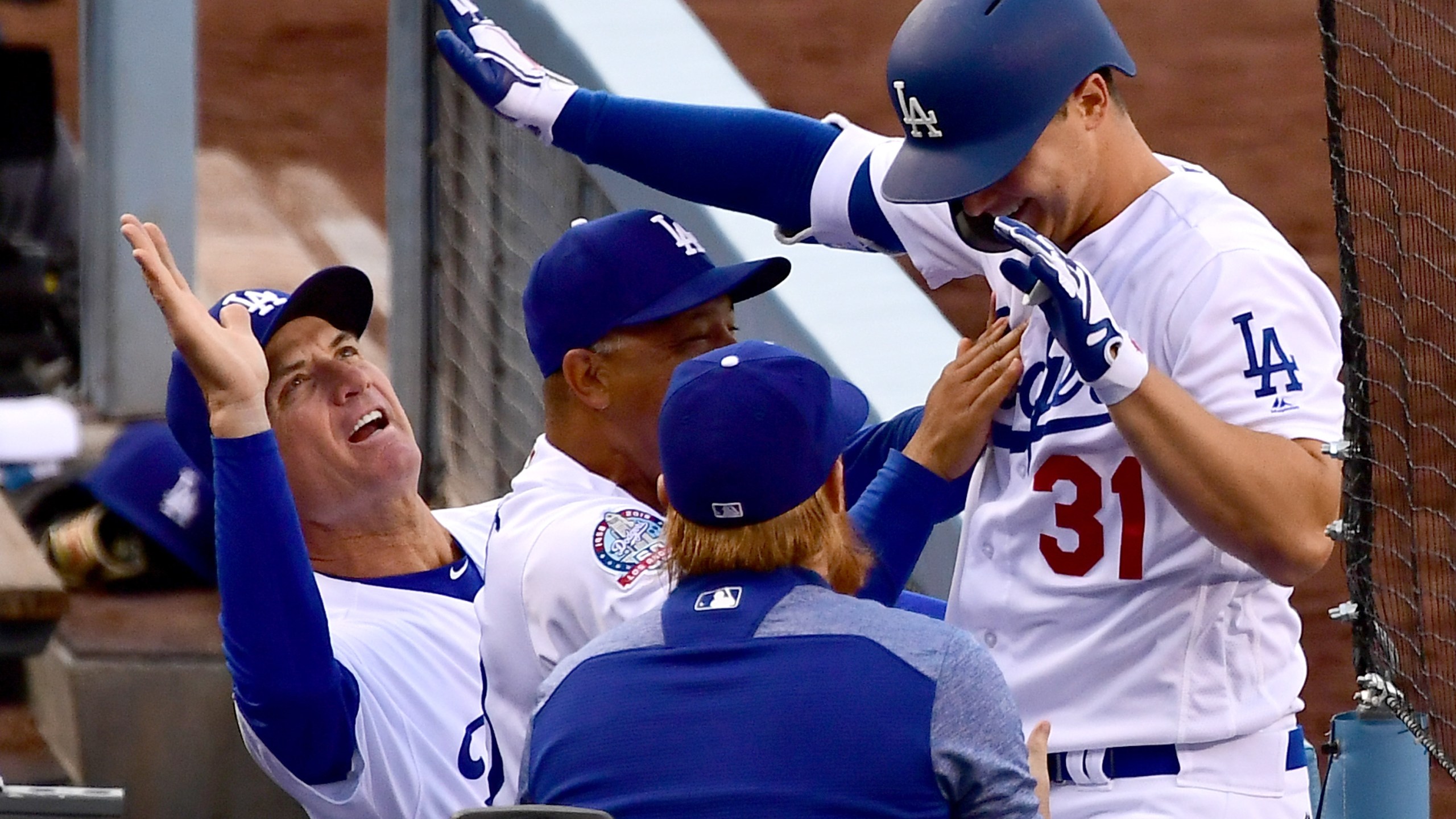 Joc Pederson is greeted in the dugout by bench coach Bob Geren and Dave Roberts of the Los Angeles Dodgers after hitting a solo home run in the second inning of the game against the Washington Nationals at Dodger Stadium on April 21, 2018. (Credit: Jayne Kamin-Oncea / Getty Images)