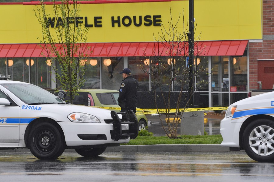 A law enforcement officer stands outside a Waffle House where four people were killed and two were wounded after a gunman opened fire with an assault weapon on April 22, 2018 in Nashville, Tennessee. (Credit: Jason Davis/Getty Images)