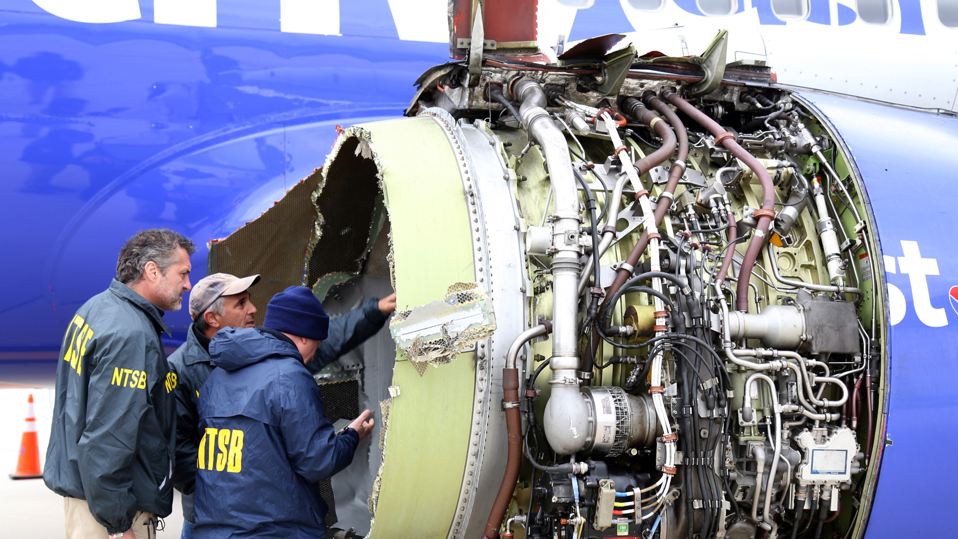 In this National Transportation Safety Board handout, NTSB investigators examine damage to the CFM International 56-7B turbofan engine belonging to Southwest Airlines Flight 1380 that separated during a flight, resulting in a female passenger's death. (Credit: Keith Holloway/National Transportation Safety Board via Getty Images)