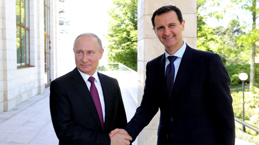 Russian President Vladimir Putin (L) shakes hands with his Syrian counterpart Bashar al-Assad during their meeting in Sochi on May 17, 2018. (Credit: MIKHAIL KLIMENTYEV/AFP/Getty Images)