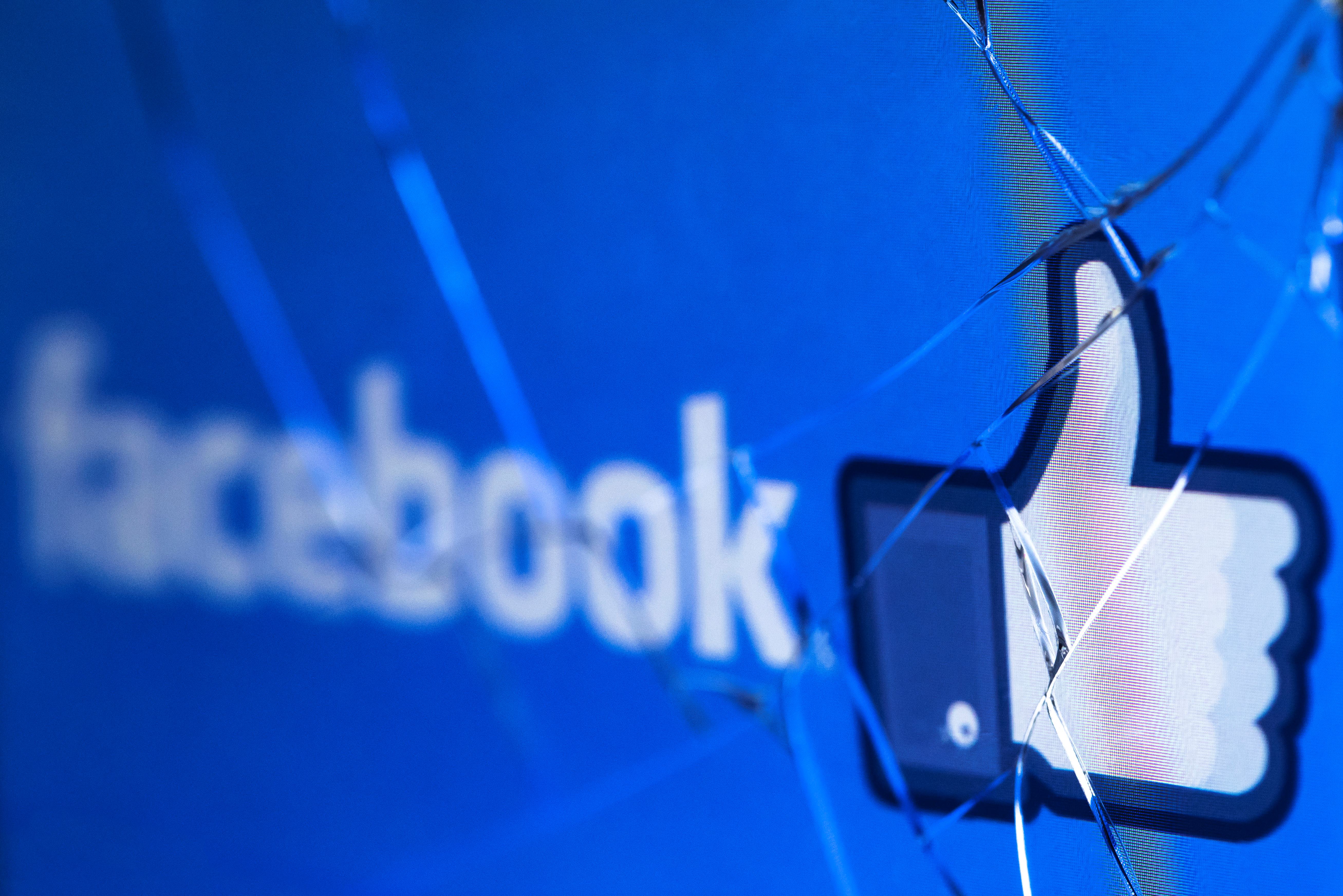 A picture taken in Paris on May 16, 2018 shows the logo of the social network Facebook on a broken screen of a mobile phone. (Credit: JOEL SAGET/AFP/Getty Images)