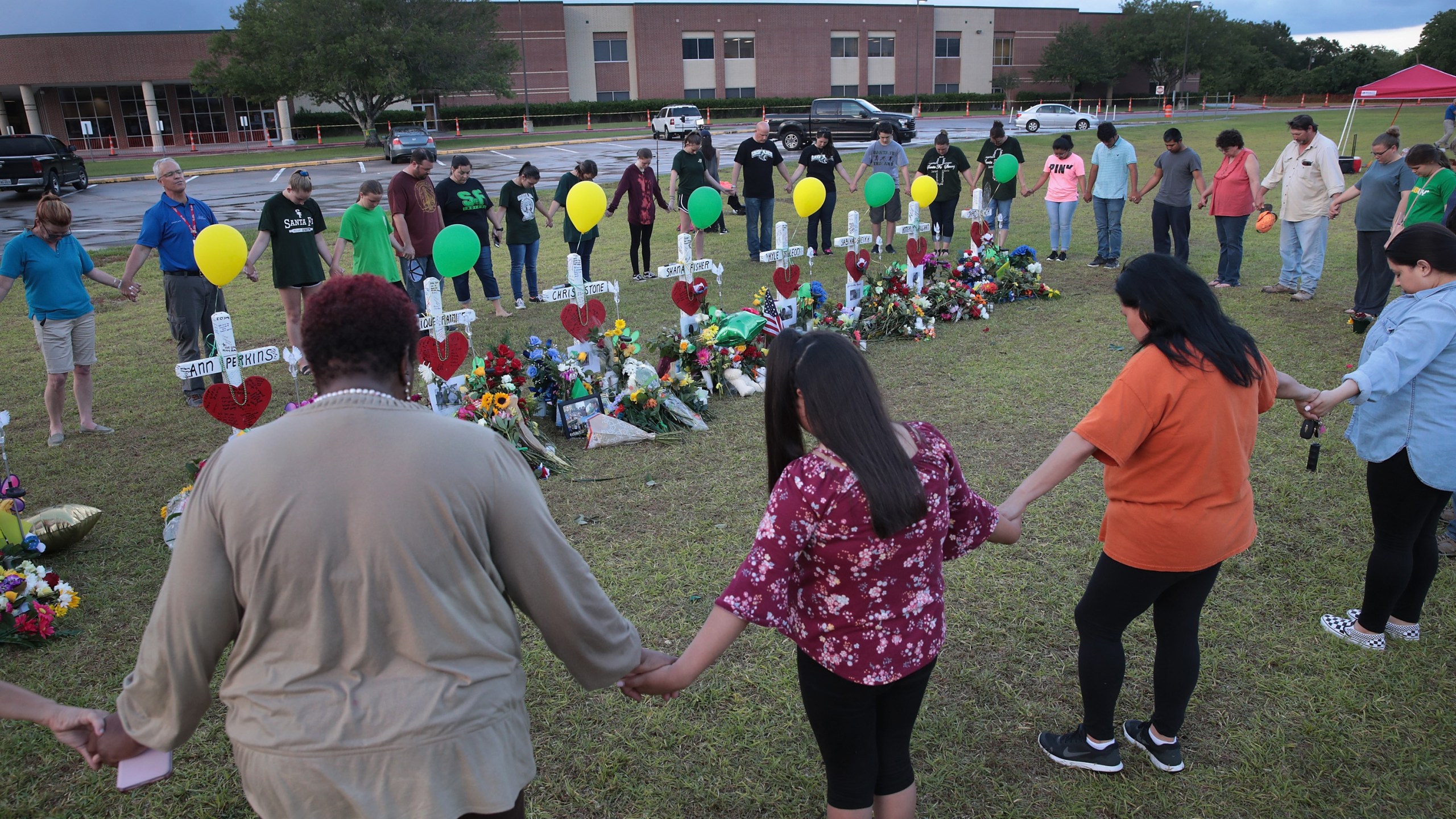 Mourners pray around a memorial in front of Santa Fe High School on May 21, 2018 in Santa Fe, Texas. (Credit: Scott Olson/Getty Images)