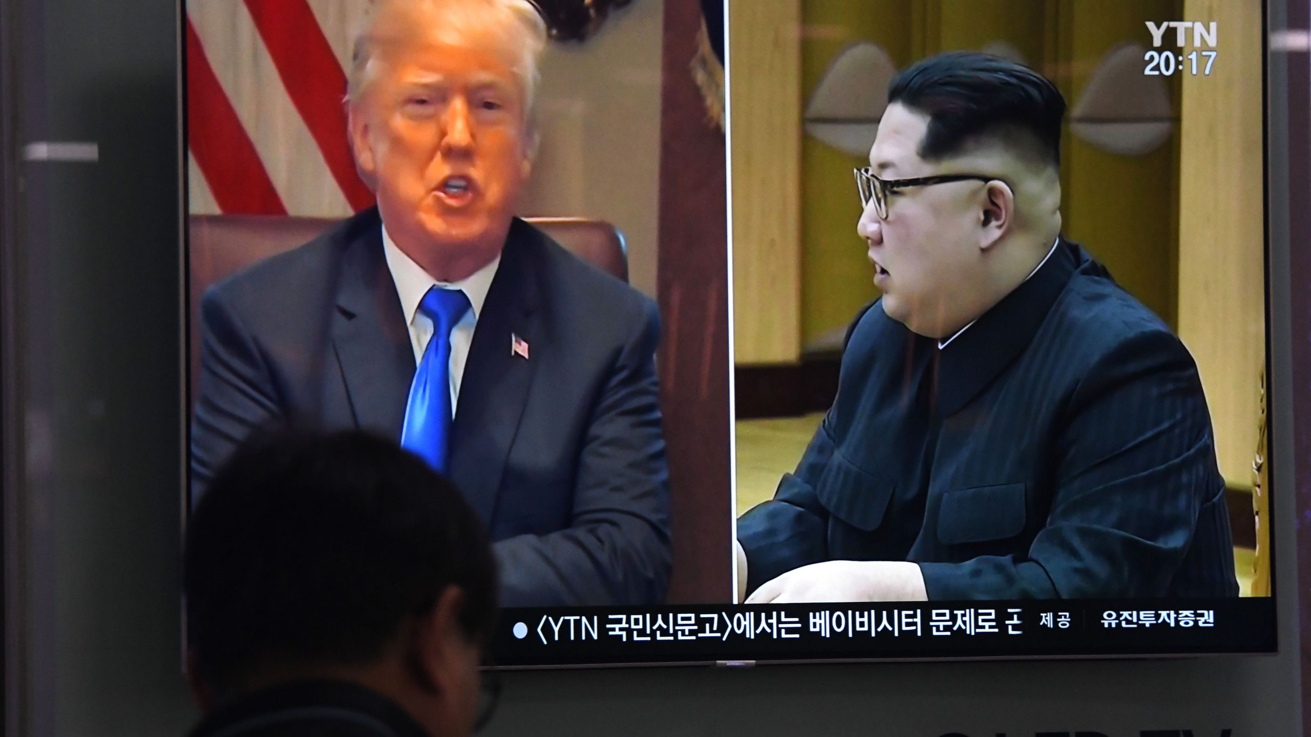 A man watches a television news showing North Korean leader Kim Jong Un and Donald Trump at a railway station in Seoul on May 24, 2018. (Credit: Jung Yeon-Je/AFP/Getty Images)