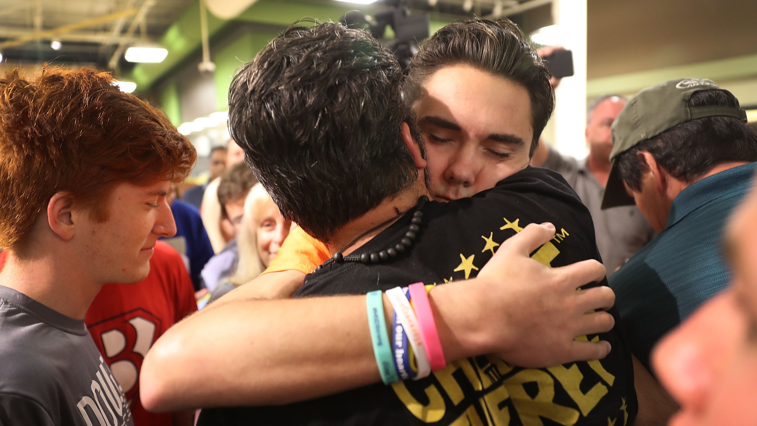 David Hogg hugs Manuel Oliver, whose son Joaquin Oliver, was killed in the Marjory Stoneman Douglas High School mass shooting as they particpate in a "die'-in" protest in a Publix supermarket on May 25, 2018, in Coral Springs, Florida. (Credit: Joe Raedle/Getty Images)