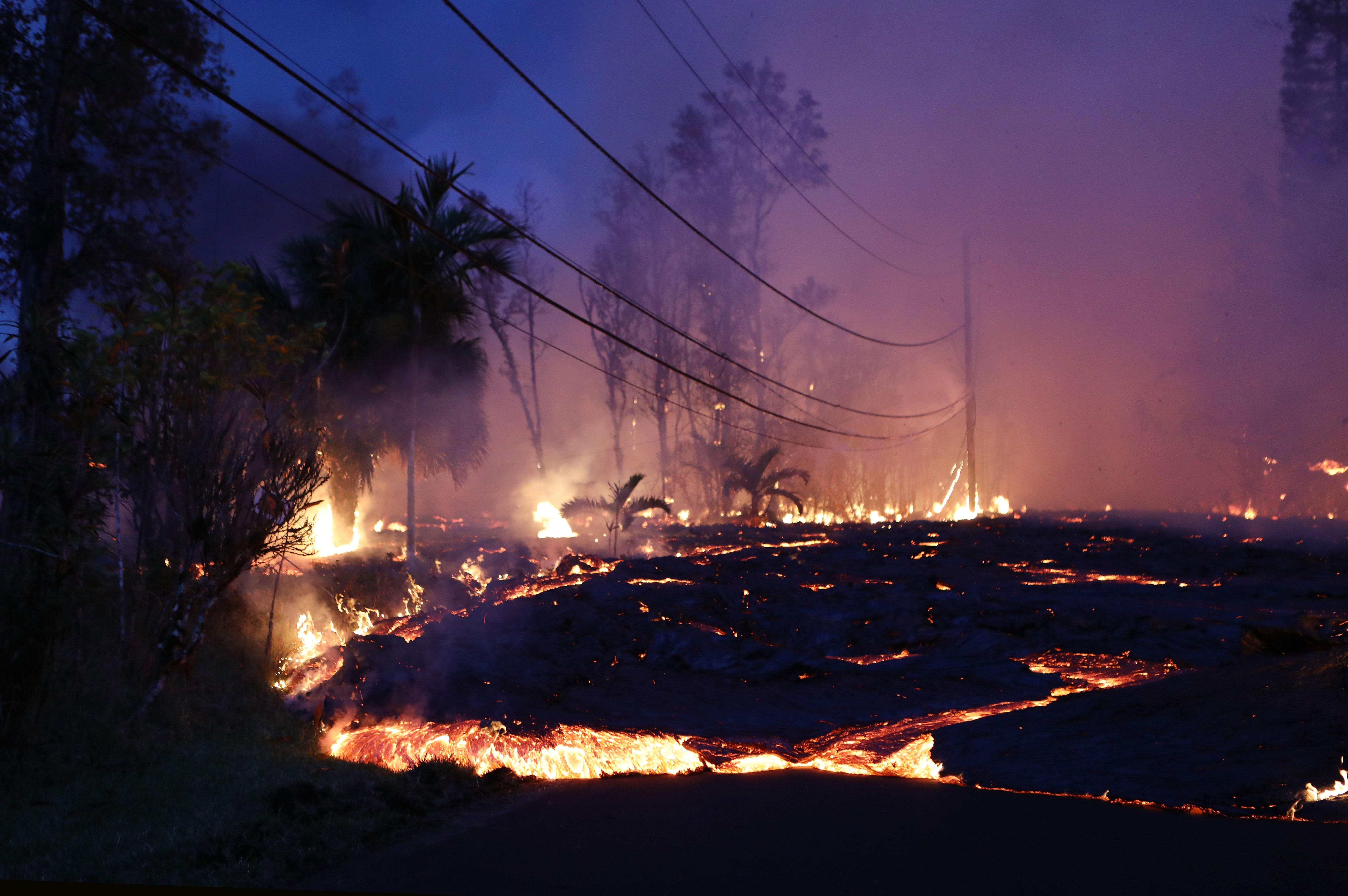 Lava from a Kilauea volcano fissure advances up a residential street in Leilani Estates, on Hawaii's Big Island, on May 27, 2018. (Credit: Mario Tama/Getty Images)