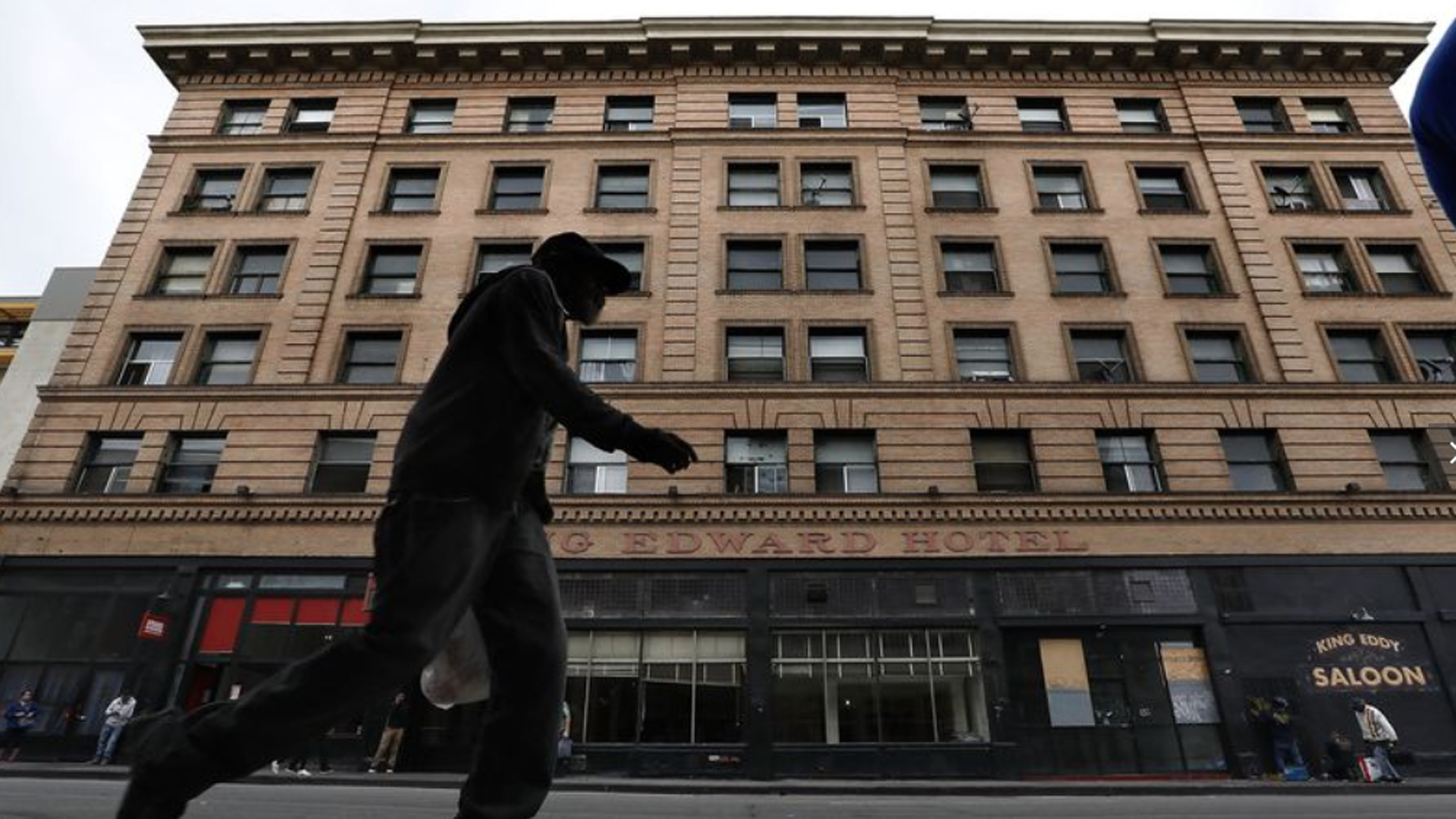 A pedestrian walks along 5th St. in downtown Los Angeles with the King Edward Hotel seen in the background. The Aids Healthcare Foundation has purchased the 106 year old hotel and plans to lease its 150 rooms to homeless people. (Credit: Mel Melcon / Los Angeles Times)