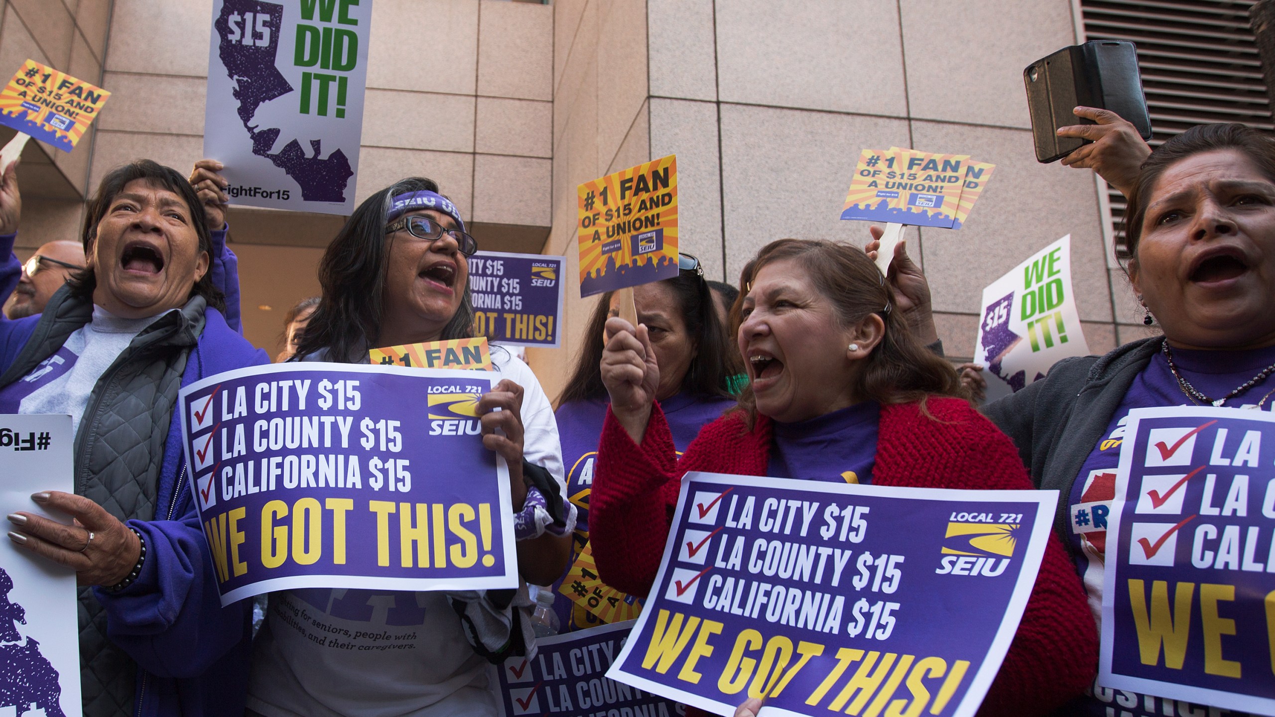 Service Employees International Union members celebrate after Jerry Brown signed landmark legislation SB 3 into law on April 4, 2016 in Los Angeles. (Credit: David McNew/Getty Images)