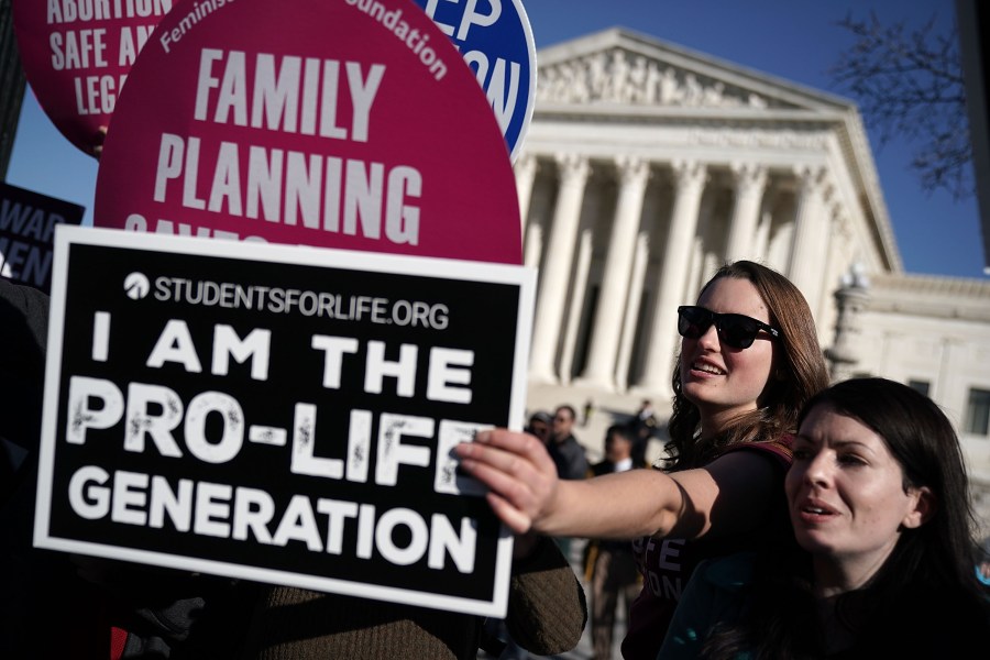 A pro-life activist tries to block the signs of pro-choice activists in front of the the U.S. Supreme Court during the 2018 March for Life January 19, 2018 in Washington, D.C. (Credit: Alex Wong/Getty Images)