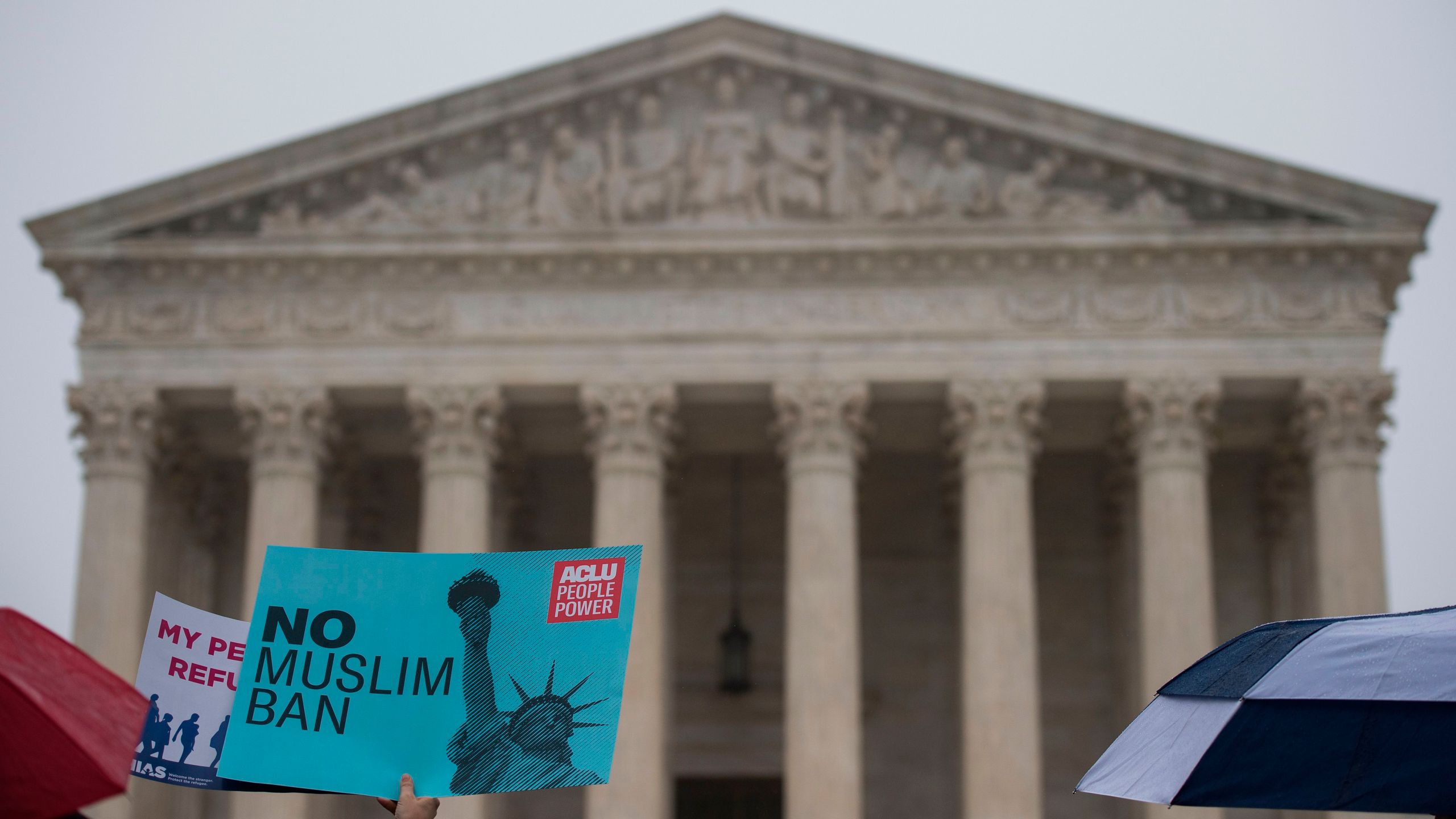 Activists rally against President Donald Trump's travel ban on April 25, 2018 — the day the Supreme Court heard arguments in Hawaii v. Trump — in front of the court in Washington, DC. (Credit: ANDREW CABALLERO-REYNOLDS / AFP / Getty Images)