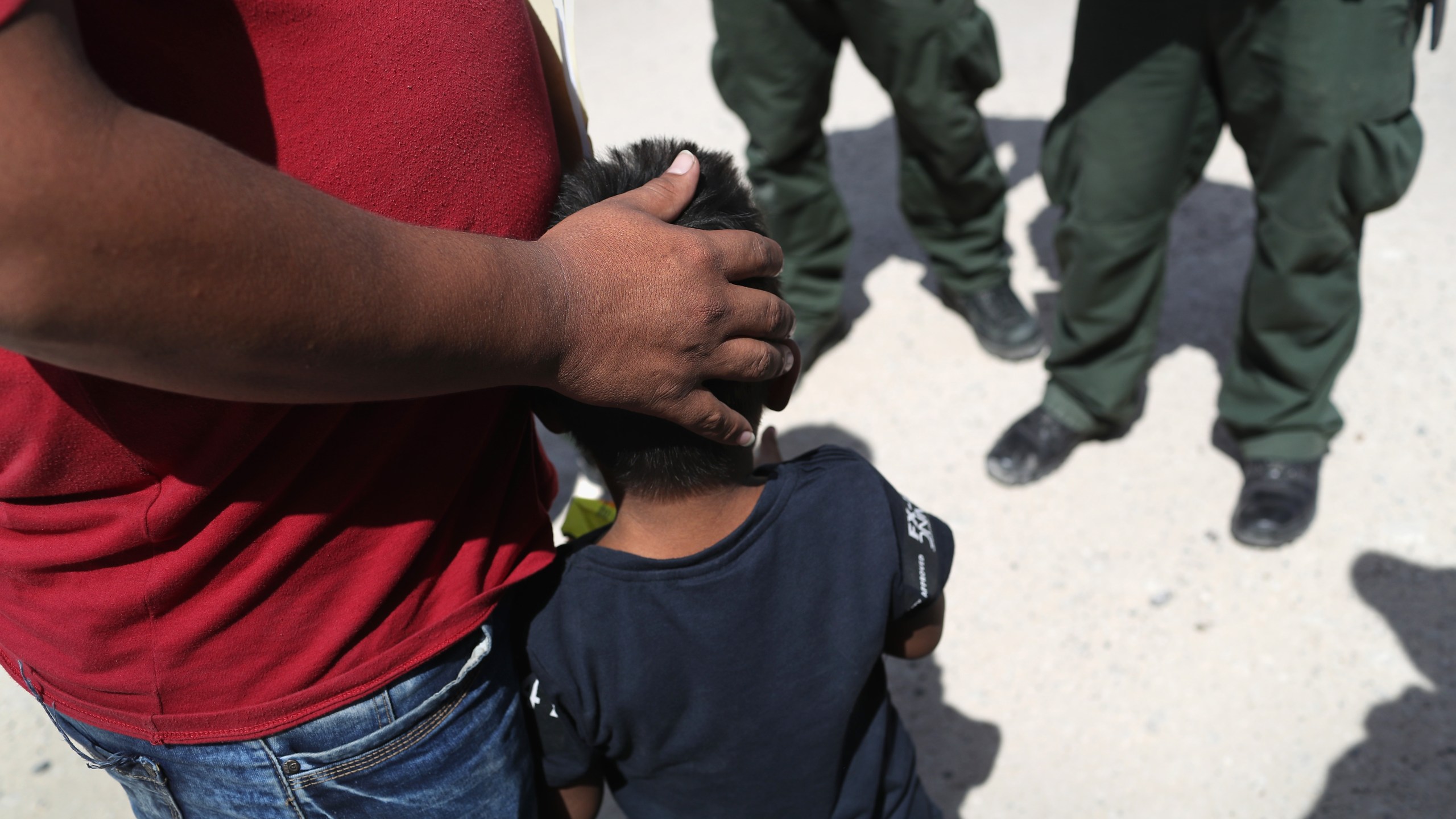 U.S. Border Patrol agents take a father and son from Honduras into custody near the U.S.-Mexico border on June 12, 2018 near Mission, Texas. (Credit: John Moore/Getty Images)