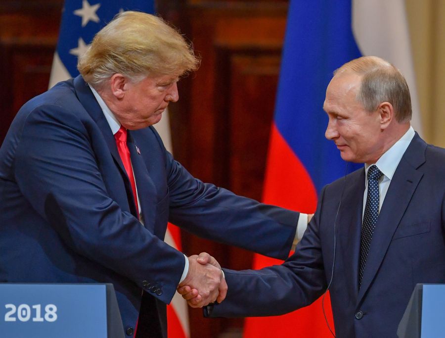 US President Donald Trump and Russia's President Vladimir Putin shake hands before attending a joint press conference after a meeting at the Presidential Palace in Helsinki, on July 16, 2018. (Credit: YURI KADOBNOV/AFP/Getty Images)