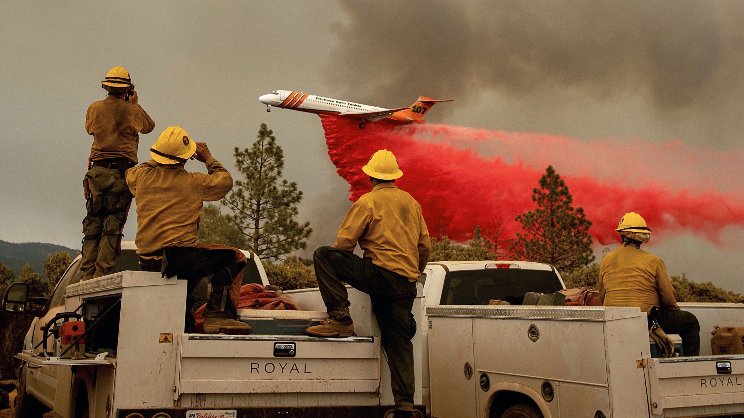 Firefighters watch as an air tanker drops retardant while battling the Ferguson fire in the Stanislaus National Forest, near Yosemite National Park, California on July 21, 2018. (Credit: NOAH BERGER/AFP/Getty Images)