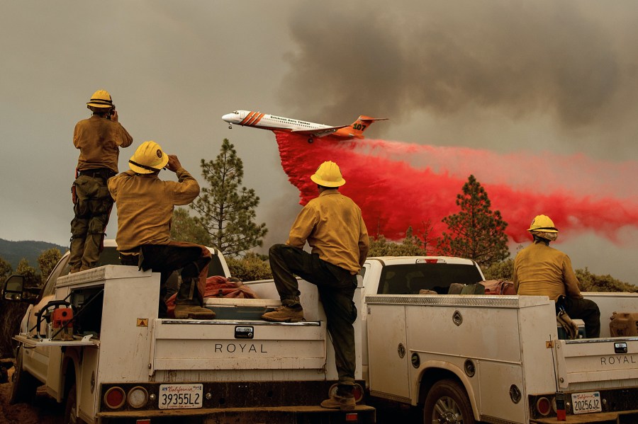 Firefighters watch as an air tanker drops retardant while battling the Ferguson fire in the Stanislaus National Forest, near Yosemite National Park, California on July 21, 2018. (Credit: NOAH BERGER/AFP/Getty Images)