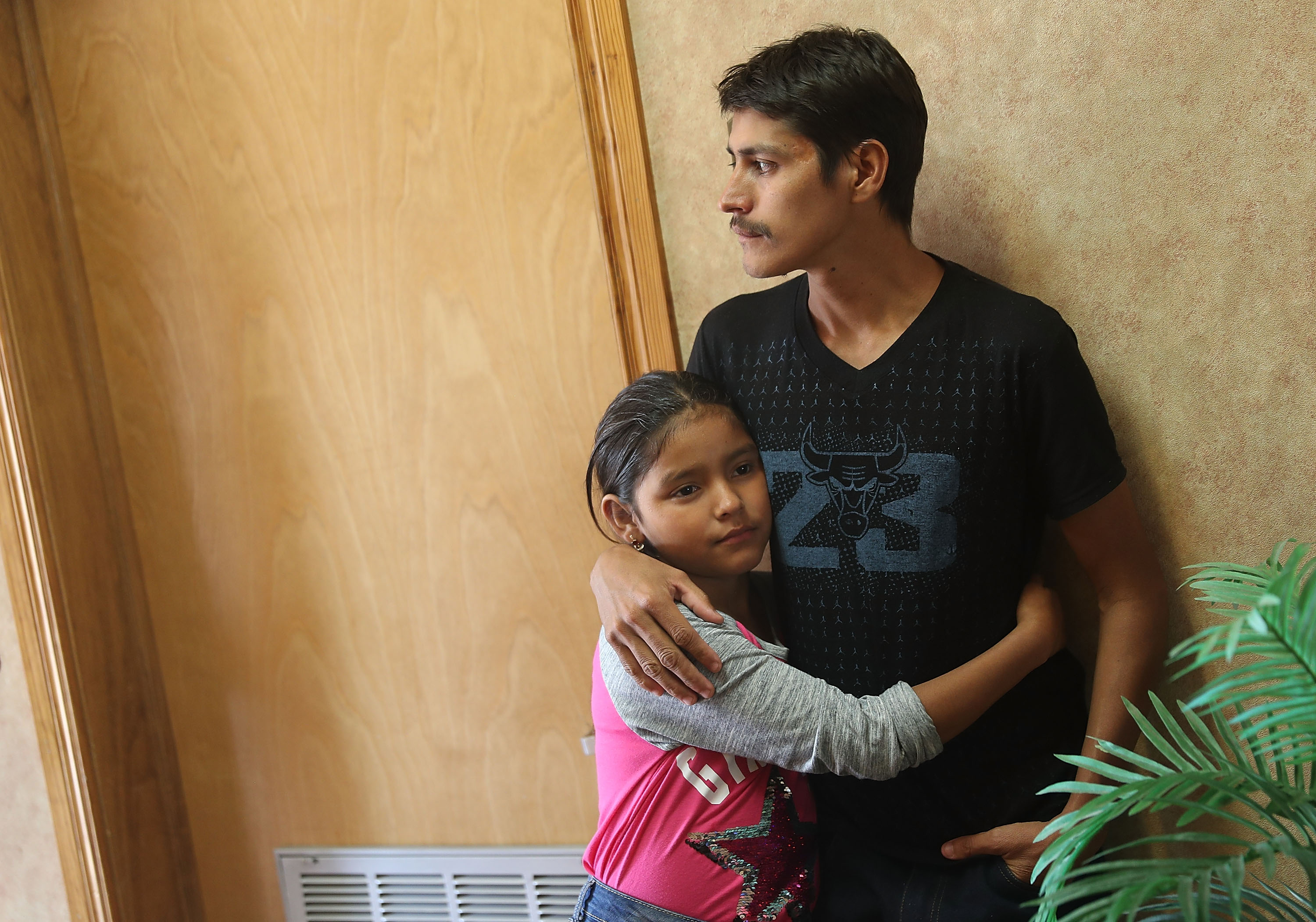 A man, identified only as Leon, spends time with his 11-year-old daughter Anaveli as they are cared for in an Annunciation House facility after they were reunited with each other on July 25, 2018 in El Paso, Texas. (Credit: Joe Raedle / Getty Images)