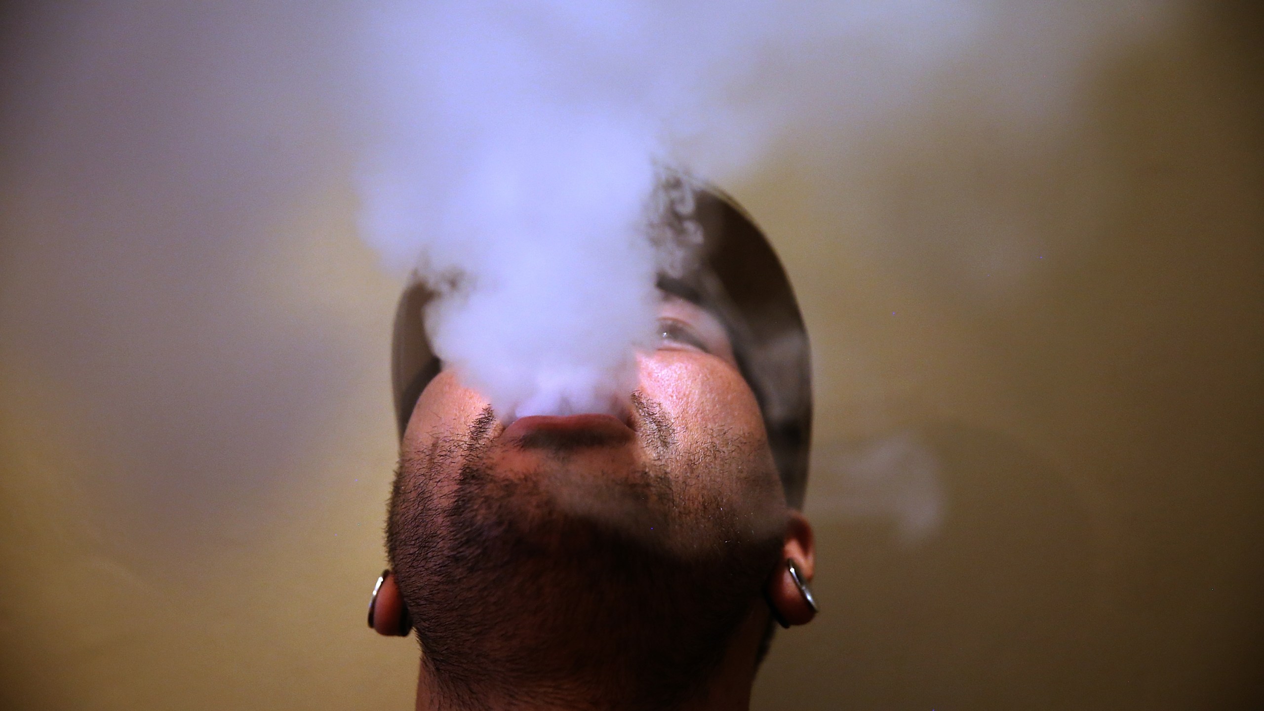 A person blows vapor from an e-cigarette on May 5, 2016 in San Francisco. (Credit: Justin Sullivan/Getty Images)