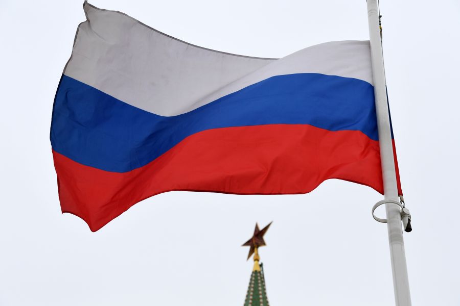 A Russian flag flies in front of a ruby star atop one of the Kremlin's towers in downtown Moscow on March 13, 2018.