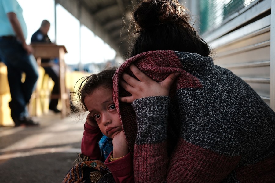 A Honduran child and her mother, fleeing poverty and violence in their home country, waits along the border bridge after being denied entry from Mexico into the U.S. on June 25, 2018 in Brownsville, Texas. (Credit: Spencer Platt/Getty Images)