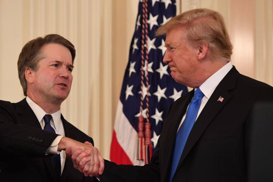 Judge Brett Kavanaugh, left, shakes hands with President Donald Trump after being nominated to the Supreme Court in the East Room of the White House on July 9, 2018. (Credit: Saul Loeb / AFP / Getty Images)