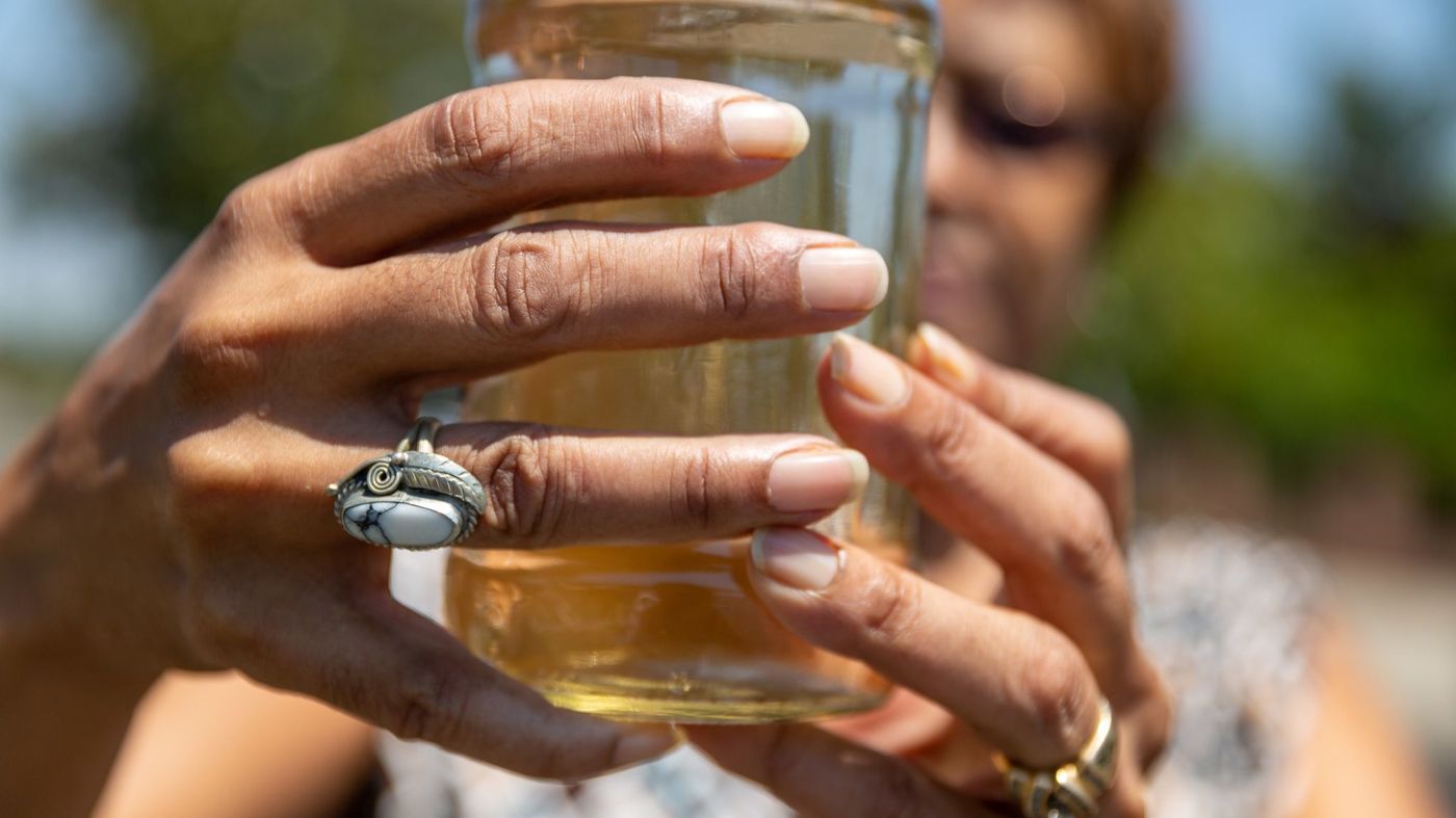 Sativa water district customer Karen Lewis holds a jar of discolored water that came from her faucet in this undated photo. (Credit: Robert Goulrey / Los Angeles Times)