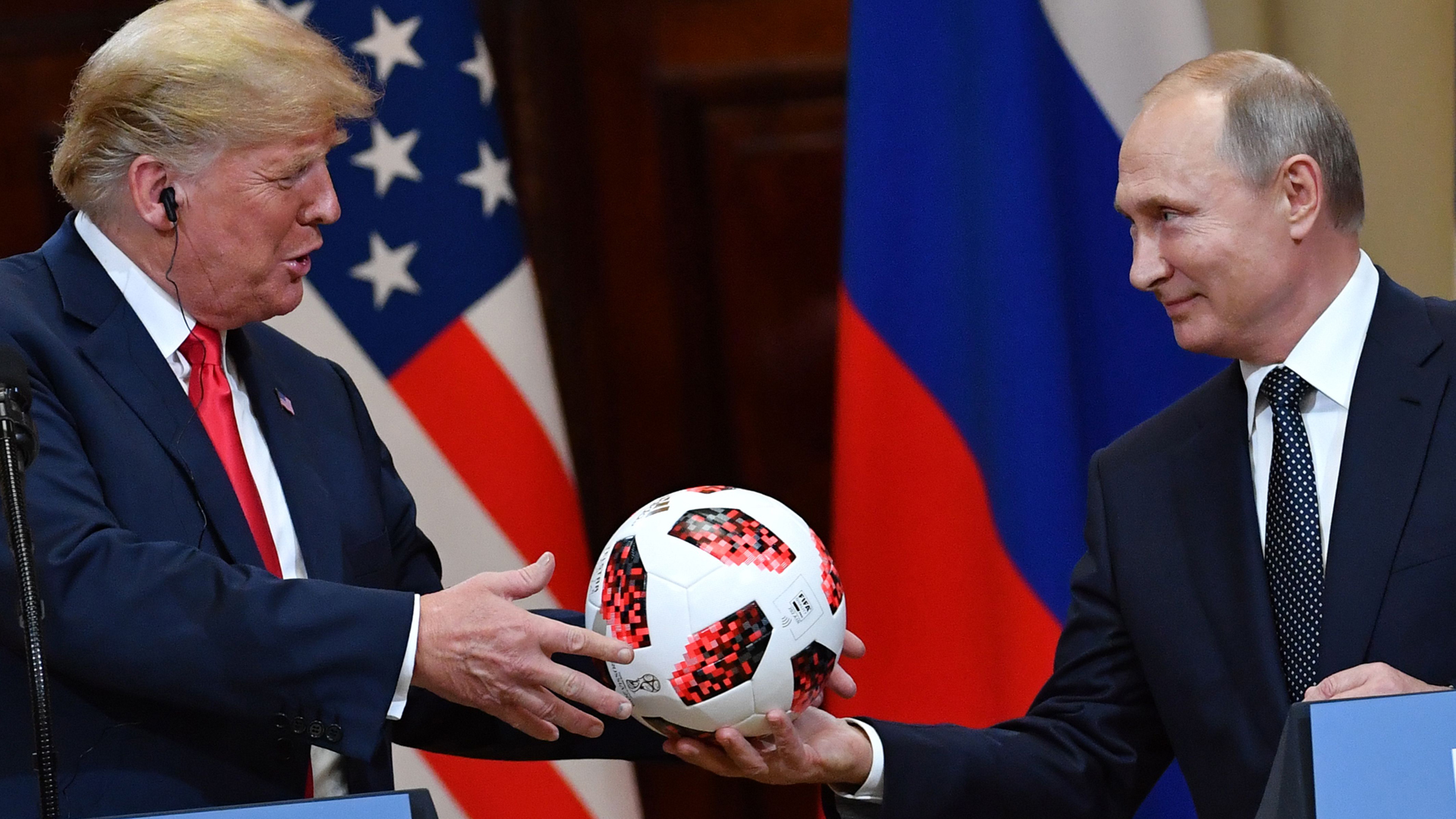 Russia's President Vladimir Putin offers a ball of the 2018 football World Cup to President Donald Trump during a joint press conference after a meeting at the Presidential Palace in Helsinki, on July 16, 2018. (Credit: YURI KADOBNOV/AFP/Getty Images)