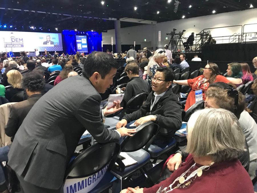 In this undated photo, Dave Min, left, lobbies California Democratic Party delegates on the convention floor, asking them to support his endorsement ahead of the primaries in 2018. (Credit: Javier Panzar / Los Angeles Times)