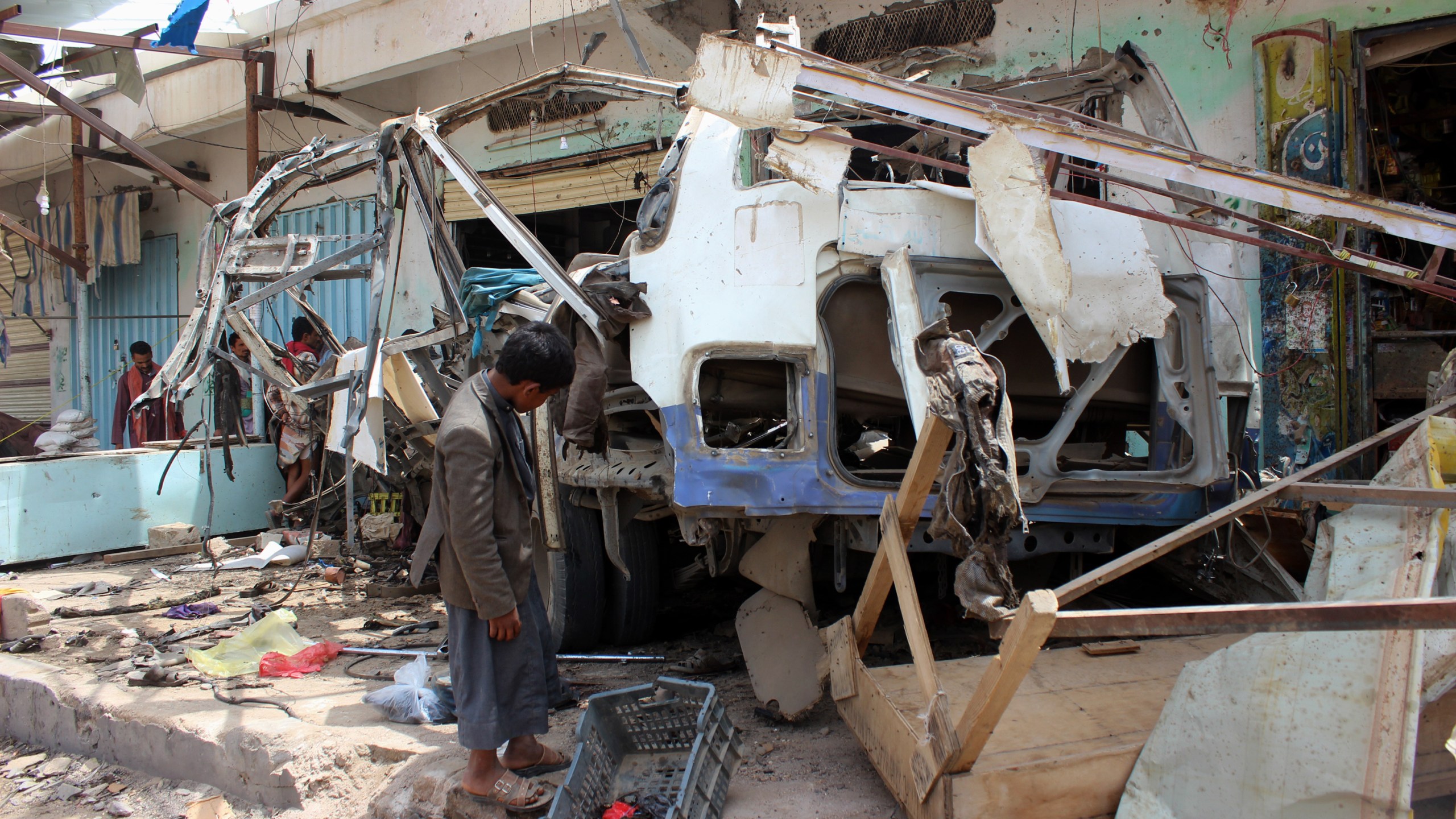 A Yemeni child stands next to the destroyed bus at the site of a Saudi-led coalition air strike, that targeted the Dahyan market the previous day in the Huthi rebels' stronghold province of Saada on August 10, 2018. (Credit: STRINGER/AFP/Getty Images)