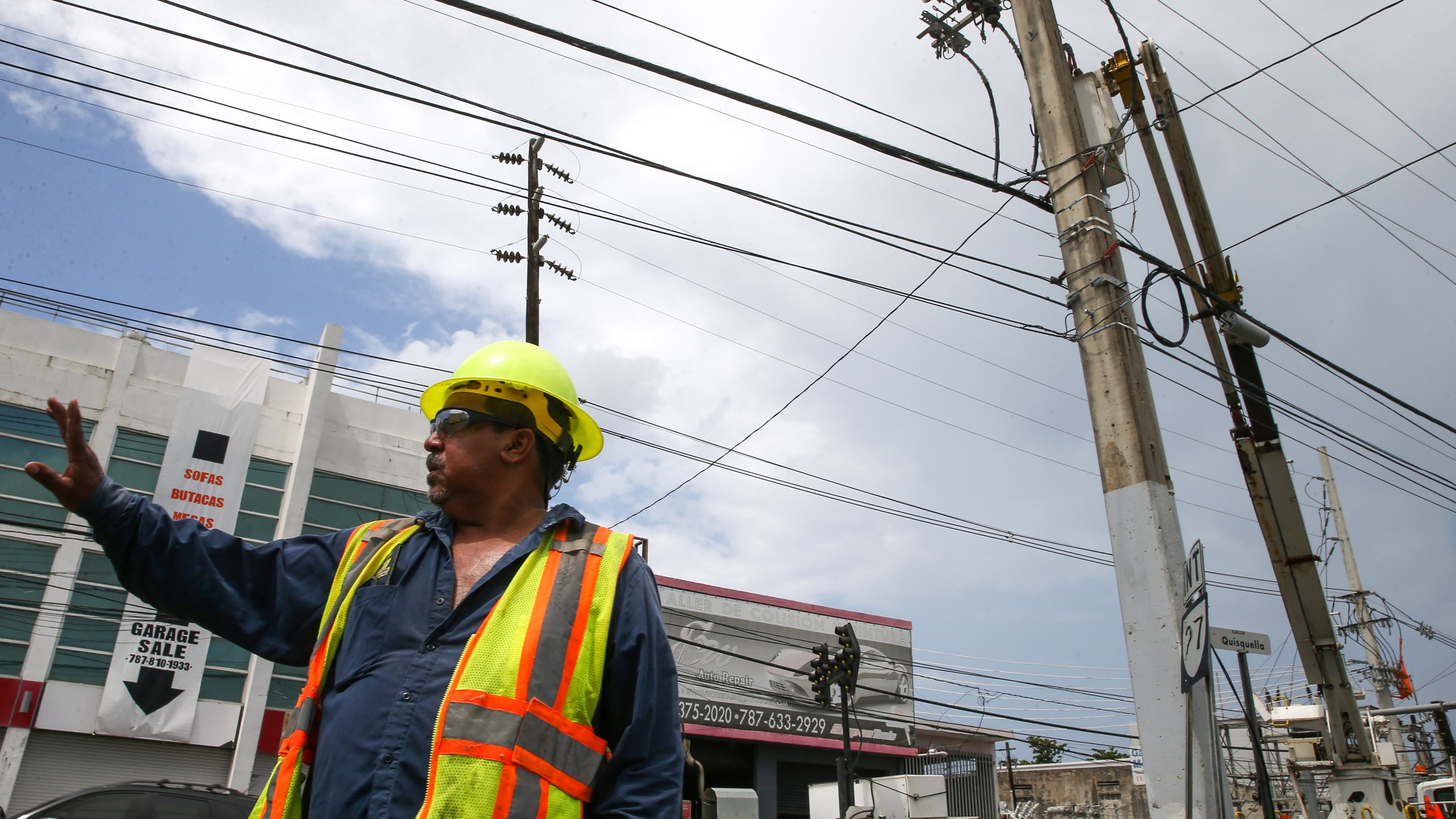 Victor Vazquez, employee of the Puerto Rico Electric Power Authority (PREPA), conducts repair work on power lines affected by Hurricane Maria, April 18, 2018 in San Juan. (Credit: Jose Jimenez Tirado / Getty Images)