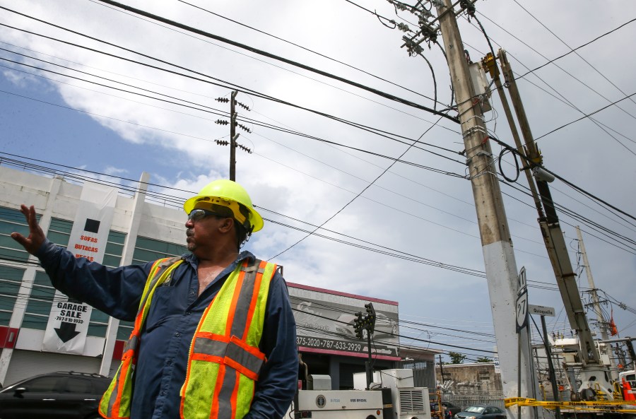 Victor Vazquez, employee of the Puerto Rico Electric Power Authority (PREPA), conducts repair work on power lines affected by Hurricane Maria, April 18, 2018 in San Juan. (Credit: Jose Jimenez Tirado / Getty Images)