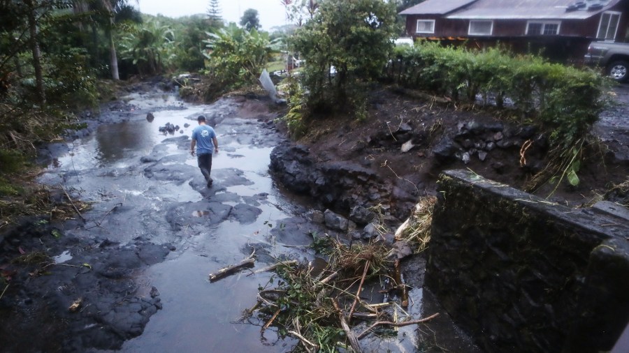 A man walks next to a home damaged by flooding from Hurricane Lane in Hilo, Hawaii, on Aug. 25, 2018. (Credit: Mario Tama/Getty Images)