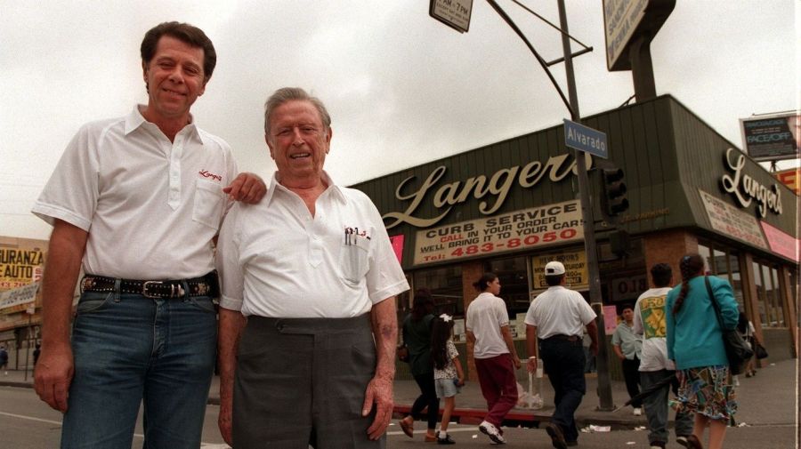 Norm Langer, left, poses with his father, Al, in front of Langer's Deli in Westlake in 1997. (Credit: Ken Hively / Los Angeles Times)